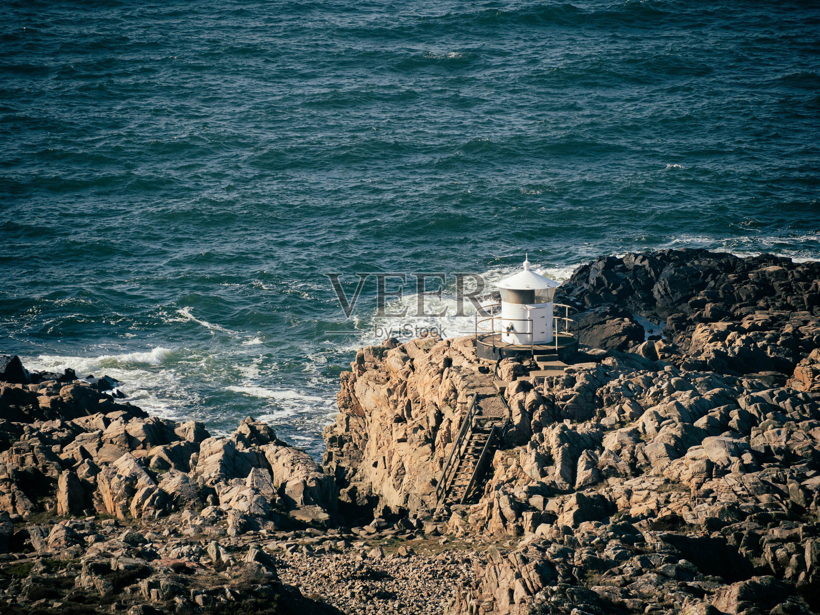 瑞典的岩石海岸，海景与边缘的小灯塔照片摄影图片