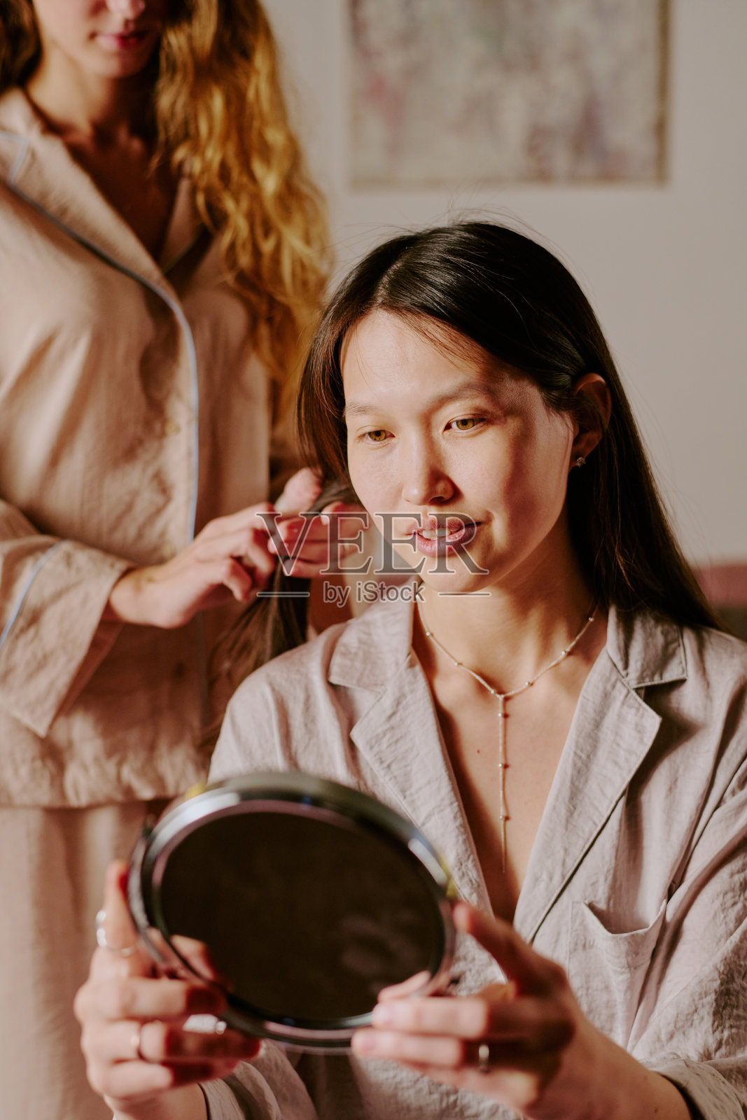 女人在镜子前看自己照片摄影图片