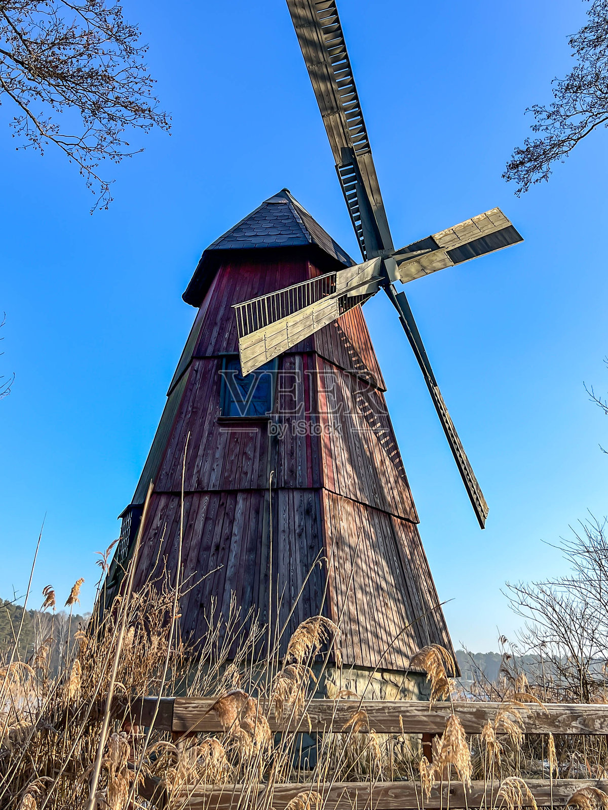波兰卡莱蒂市泽尔诺纳的池塘中小岛上的风车，冬季作为地标和旅游景点照片摄影图片