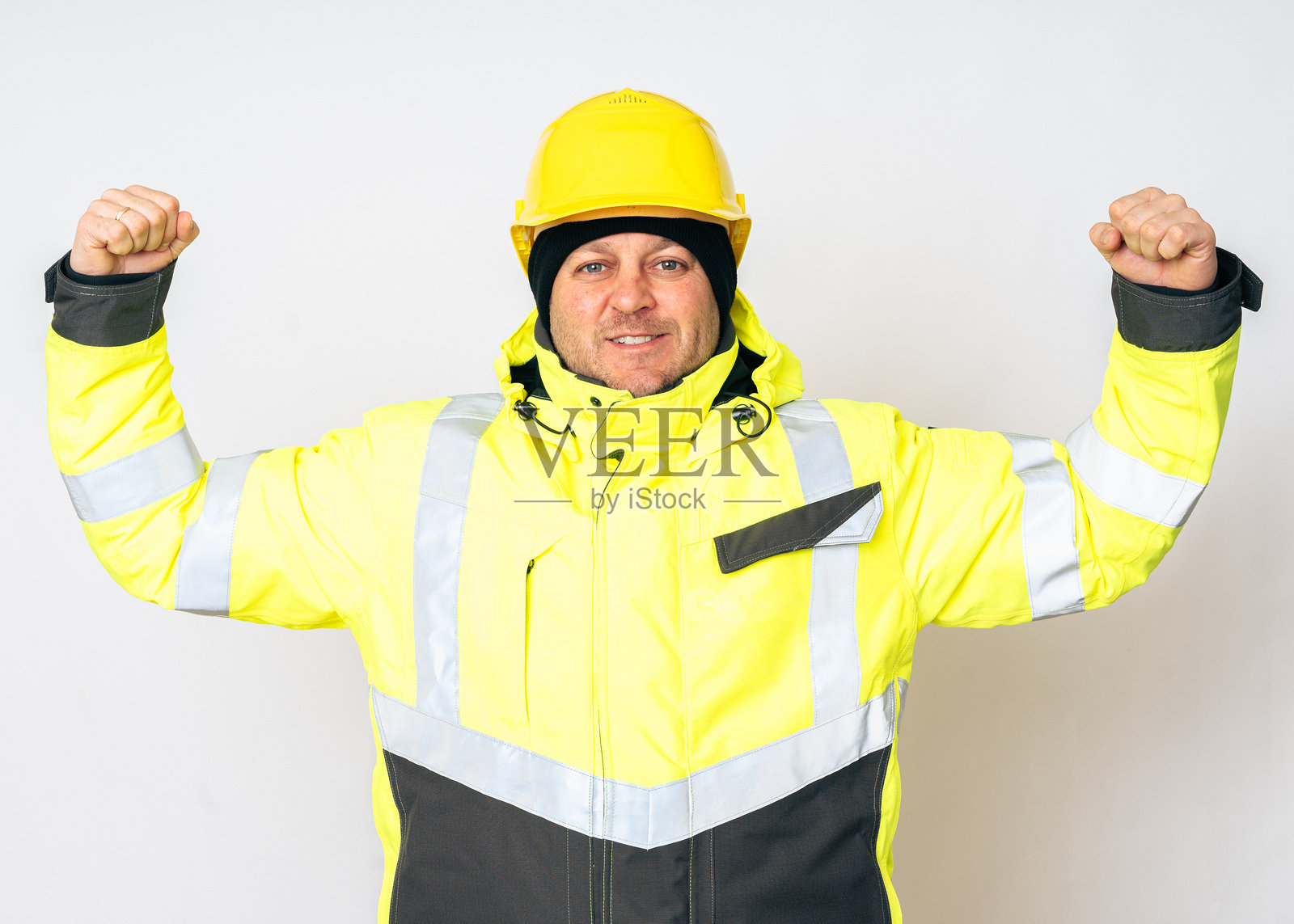 一名穿着黄色工作冬季夹克和黄色安全头盔的男子照片摄影图片
