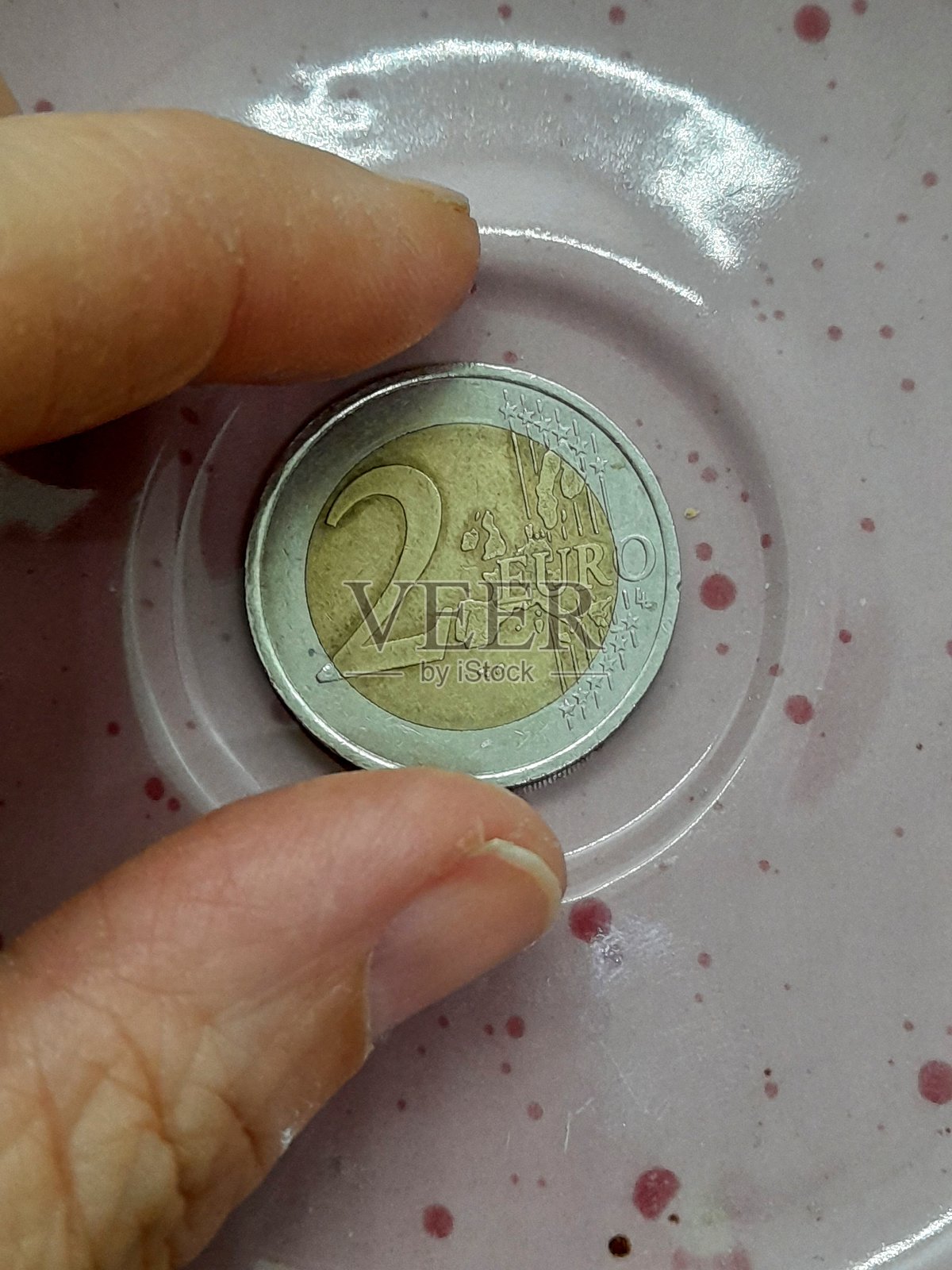 盘子上的2欧元硬币照片摄影图片