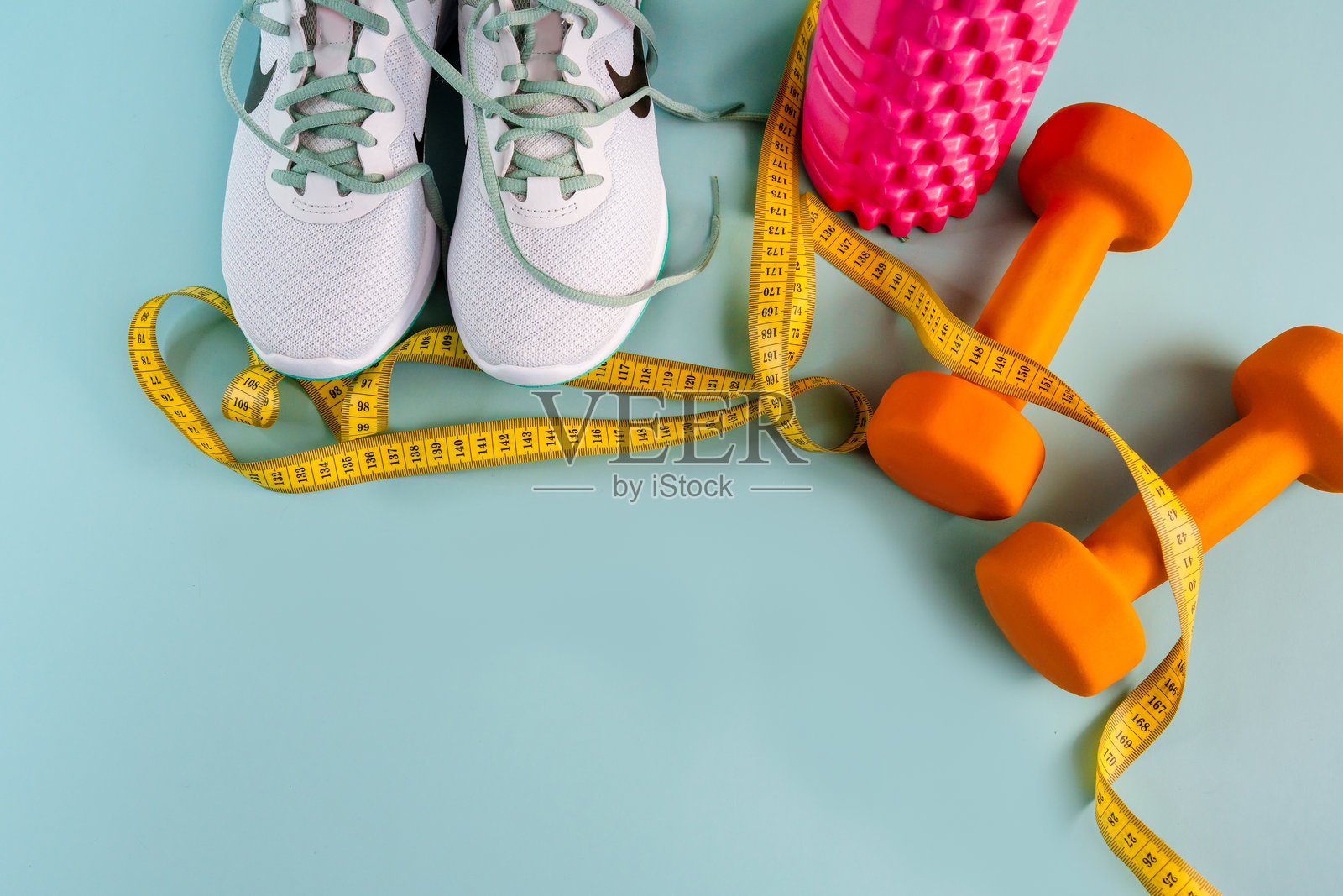 鞋子、卷尺和运动器材的组合，背景为蓝色照片摄影图片