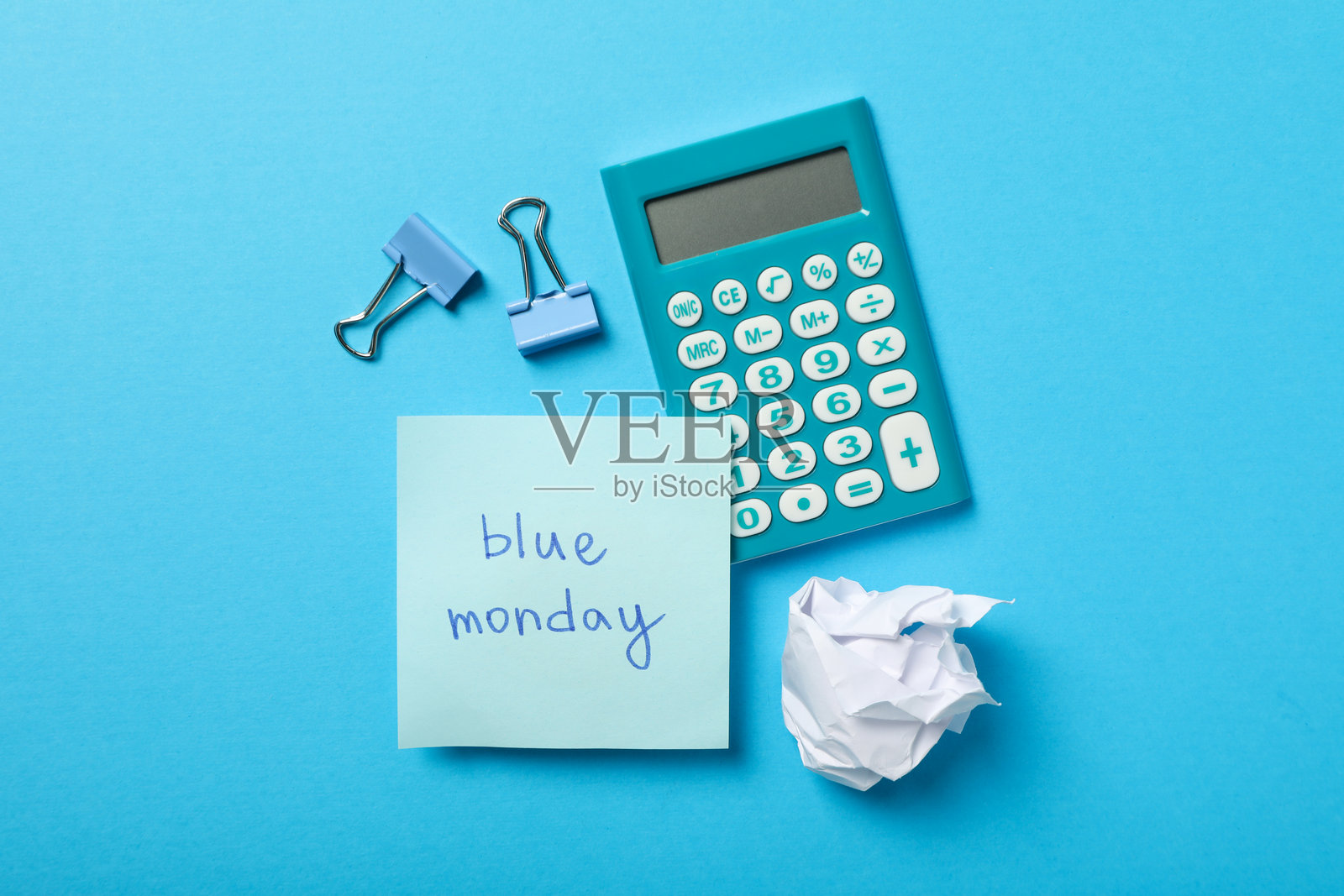 蓝色背景上的计算器、笔记本、纸张和文件夹，俯视图照片摄影图片