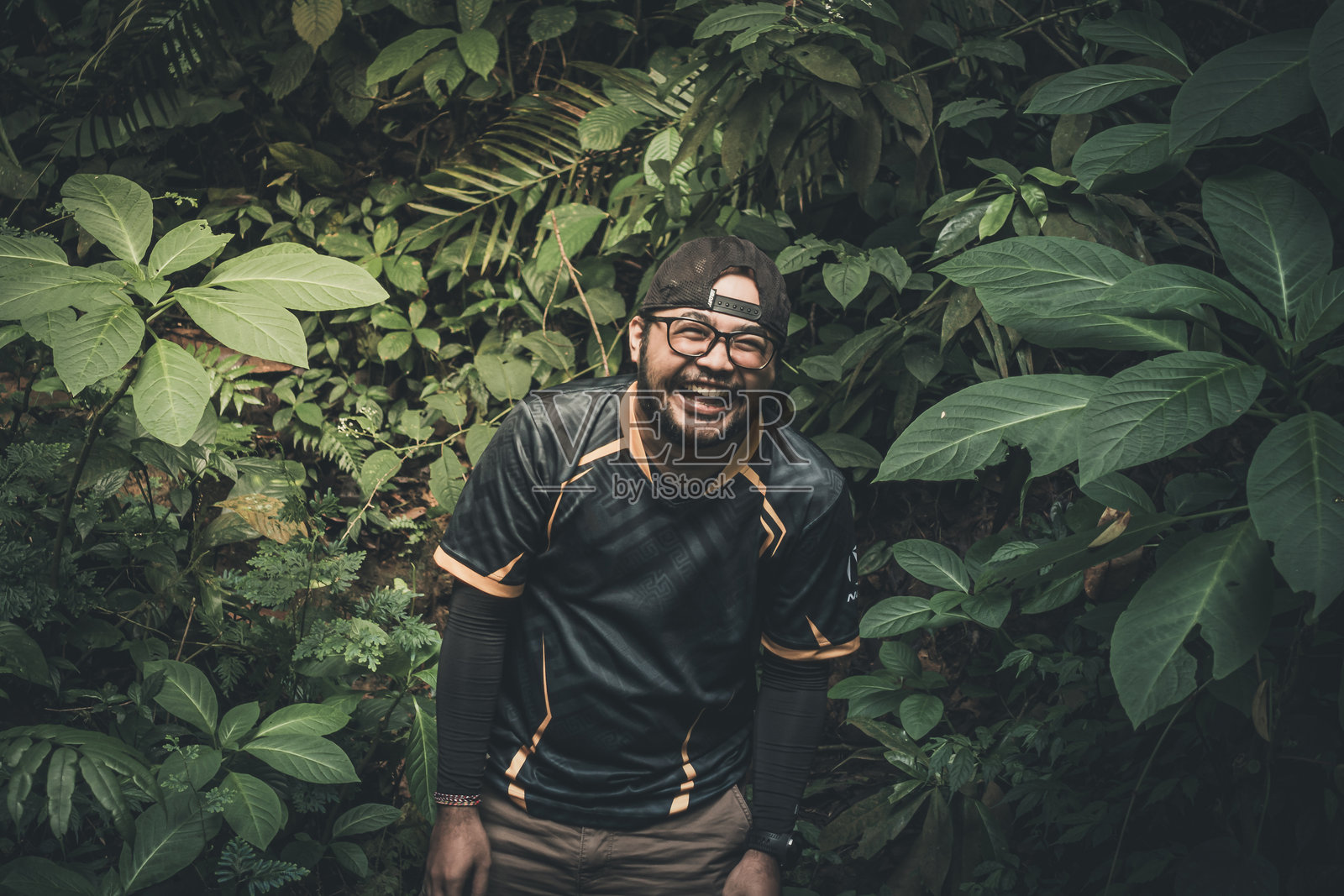 年轻男子站在植物之间的肖像照片摄影图片