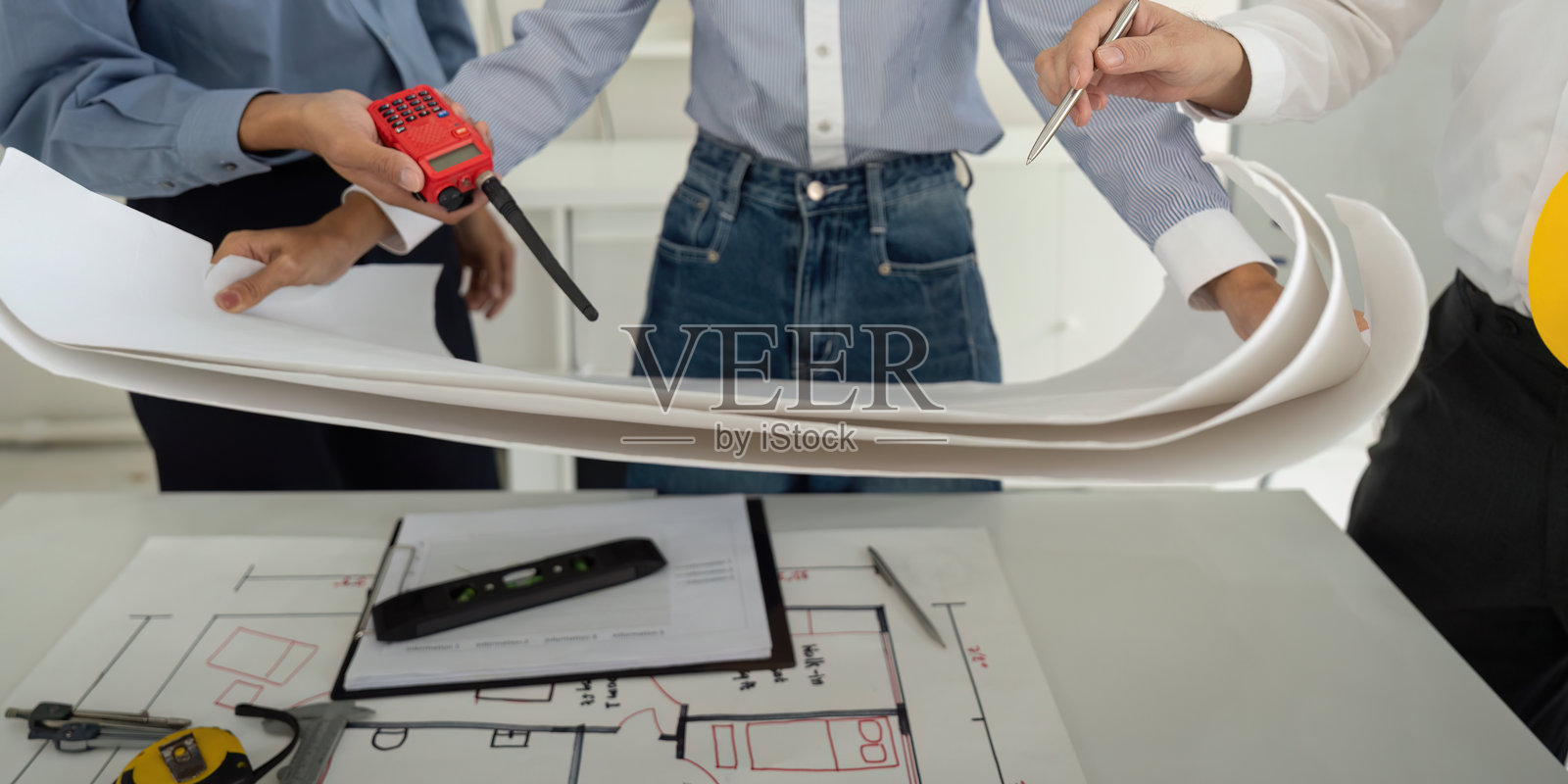 团队合作与项目讨论。专业人士专注于高效建筑设计，审查详细的施工图纸。照片摄影图片