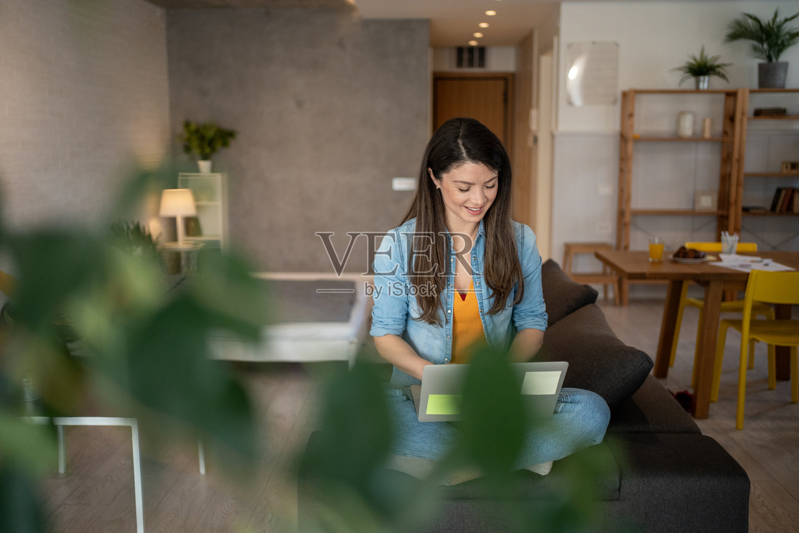 年轻女性在家中沙发上使用笔记本电脑工作照片摄影图片