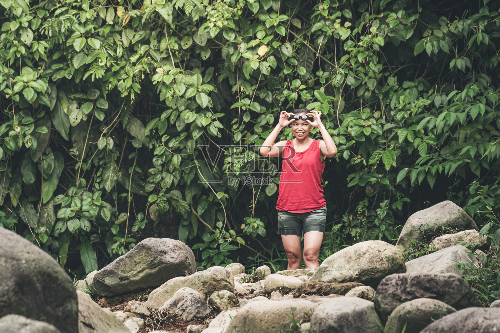 年轻女性坐在岩石上照片摄影图片