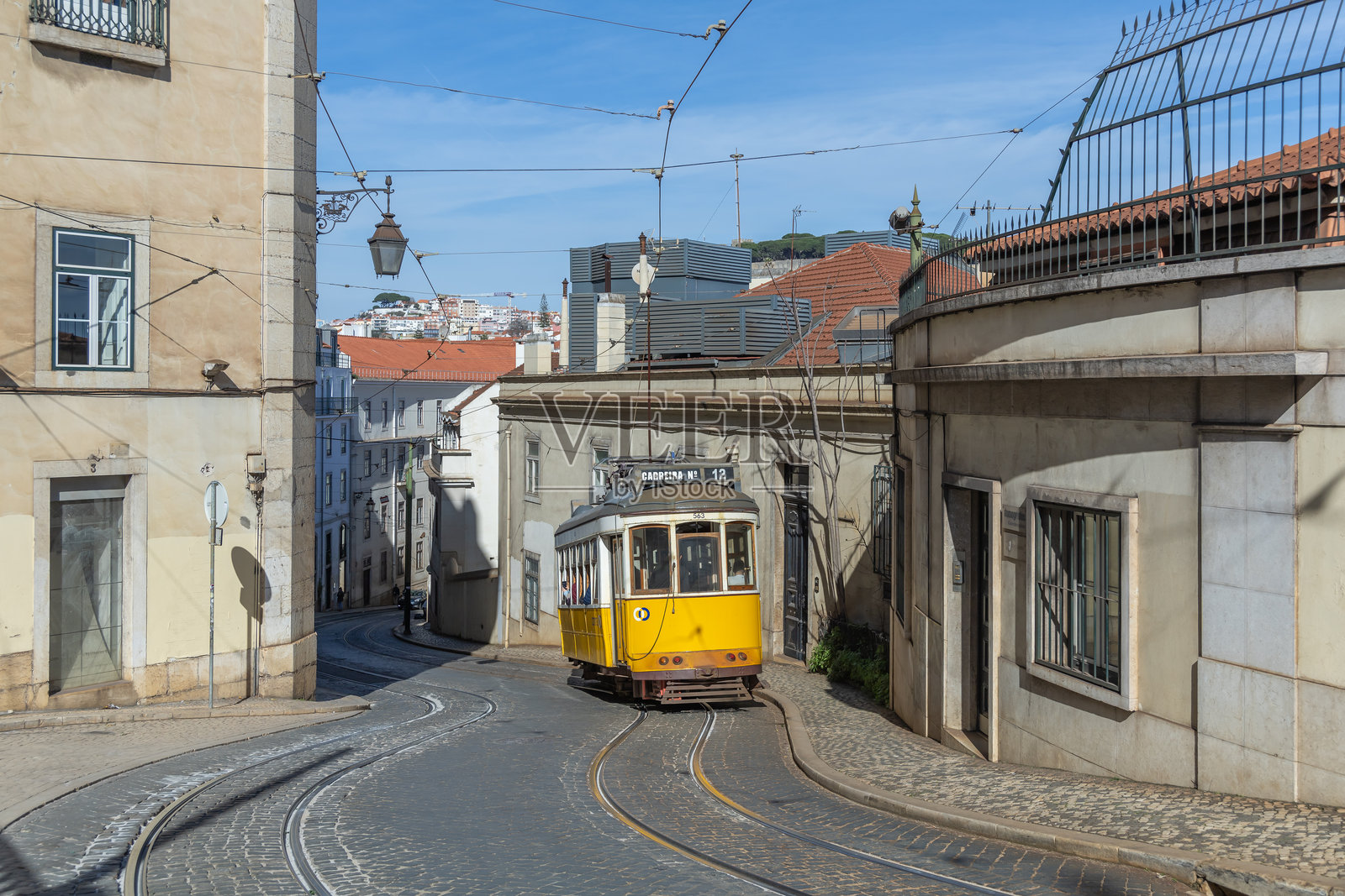 黄色电车驶过葡萄牙里斯本的建筑照片摄影图片