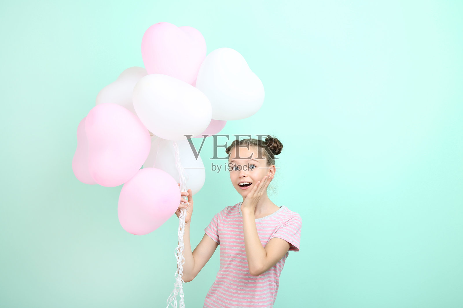 美丽的年轻女孩与薄荷色背景上的气球照片摄影图片