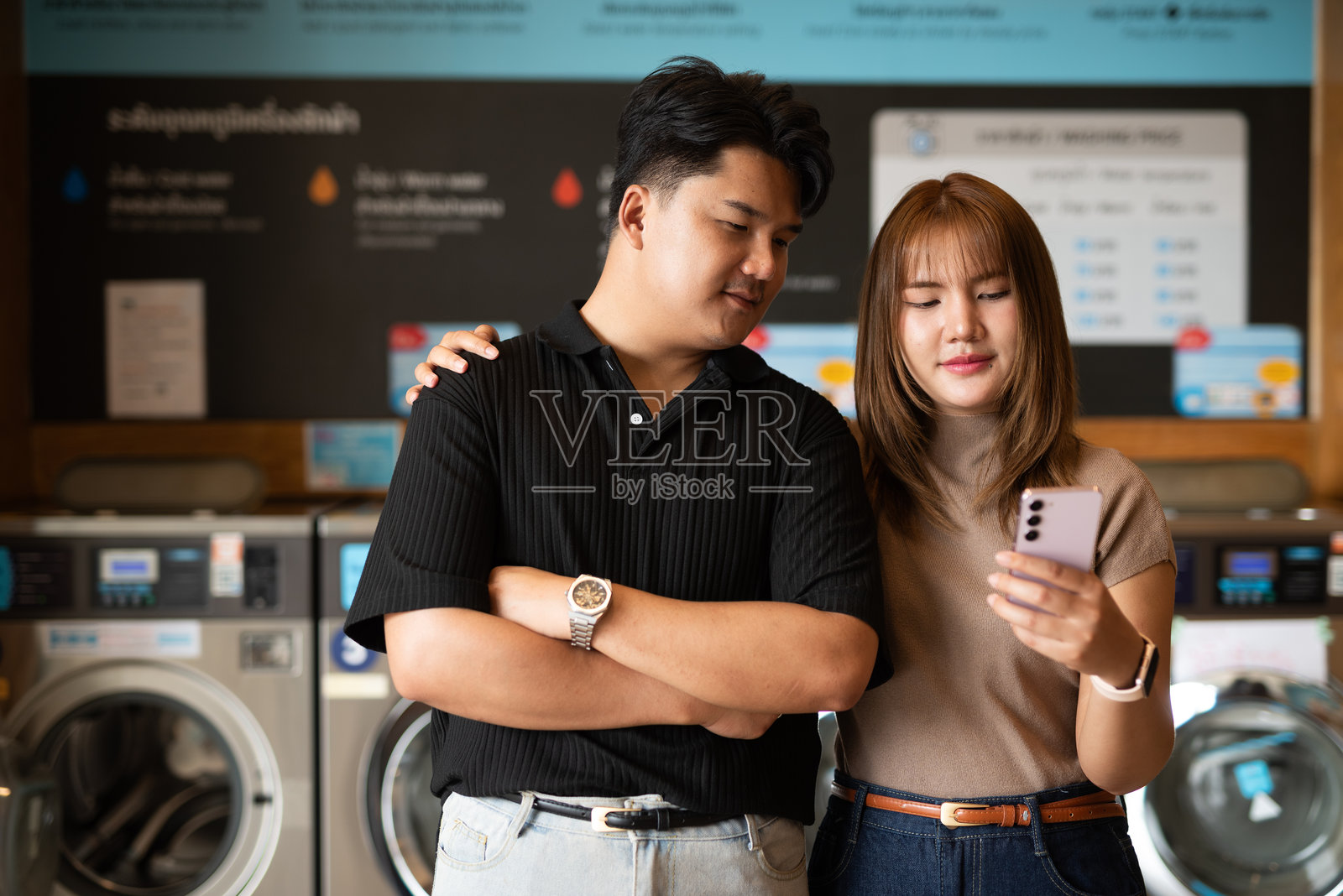 年轻的亚洲情侣在洗衣店里照片摄影图片