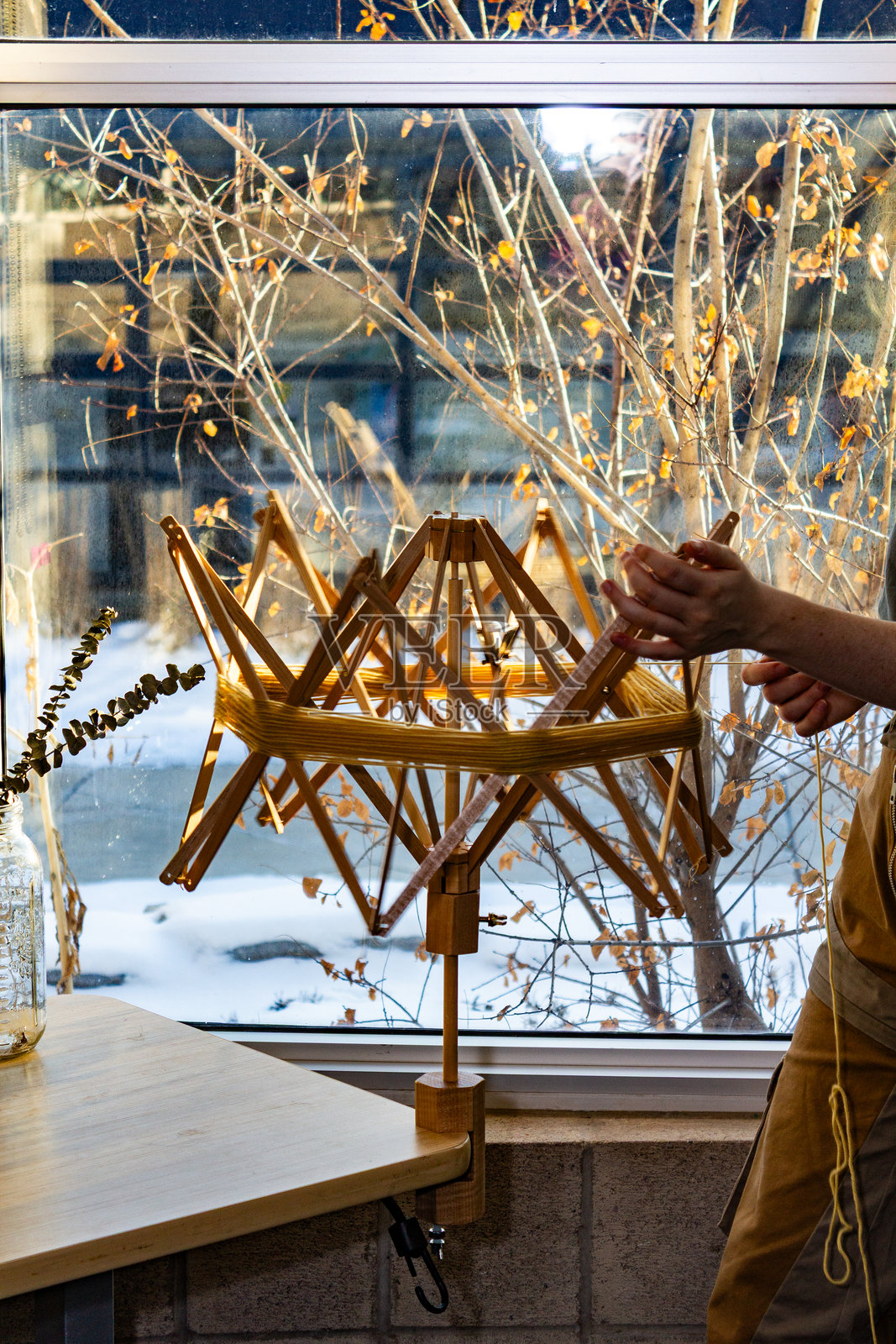 冬季工作室环境中与纺织材料一起工作的女性照片摄影图片