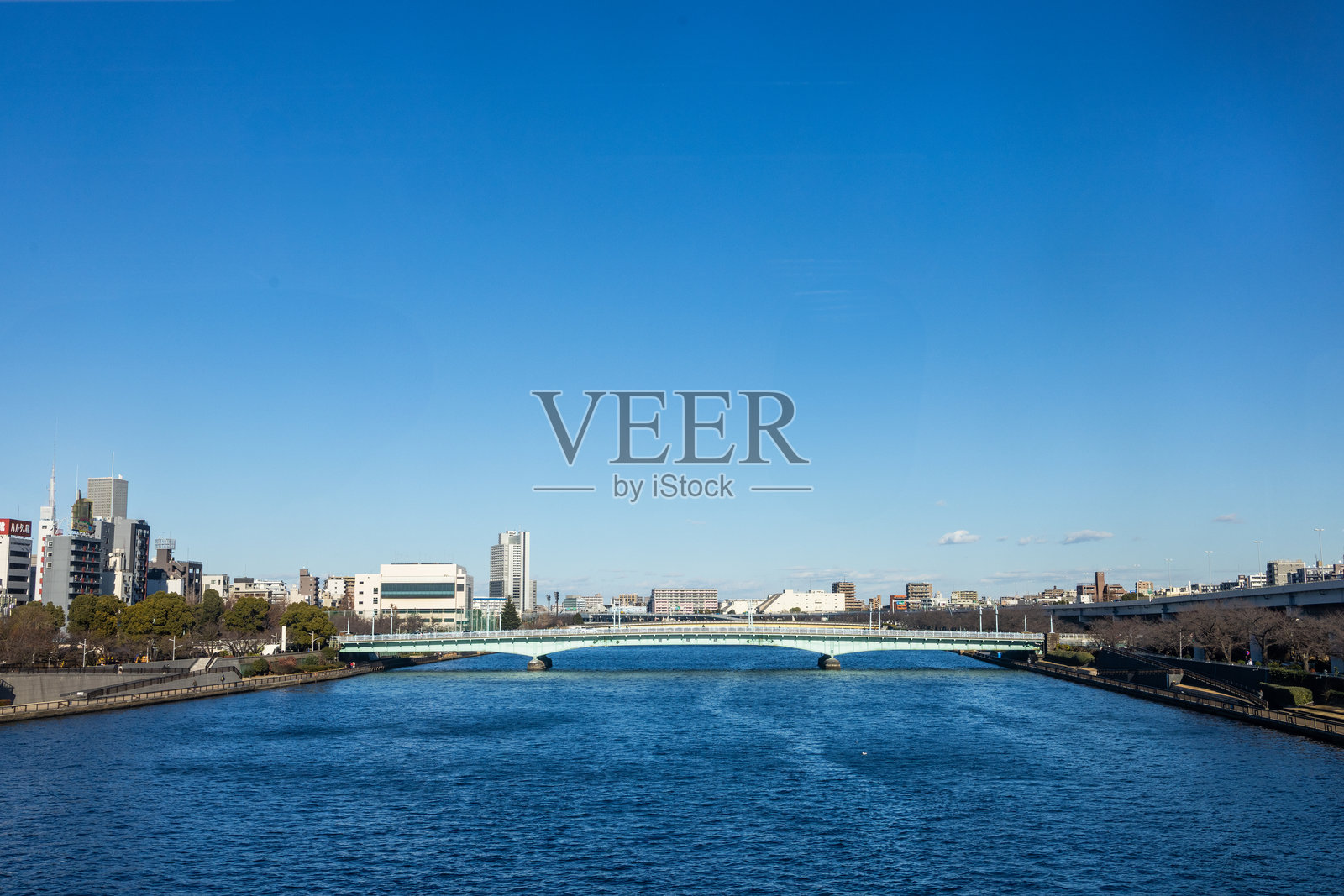 河上桥梁，清澈的天空和城市景观在背景中照片摄影图片