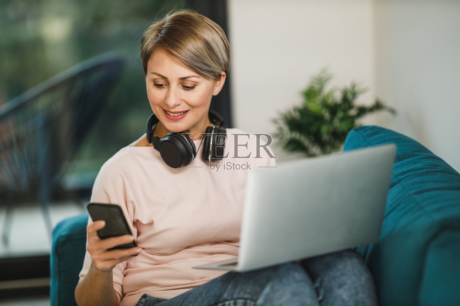 在家工作时使用智能手机和笔记本电脑的女性照片摄影图片