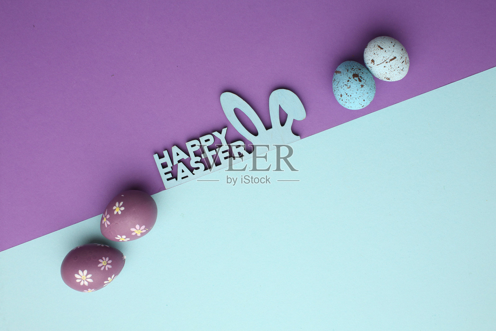 复活节假期。节日装饰。食品装饰。自制饰品。创意多彩的粉色、蓝色、黄色彩蛋排列，带有可爱的兔子和小鸡图案，背景为浅色调。照片摄影图片