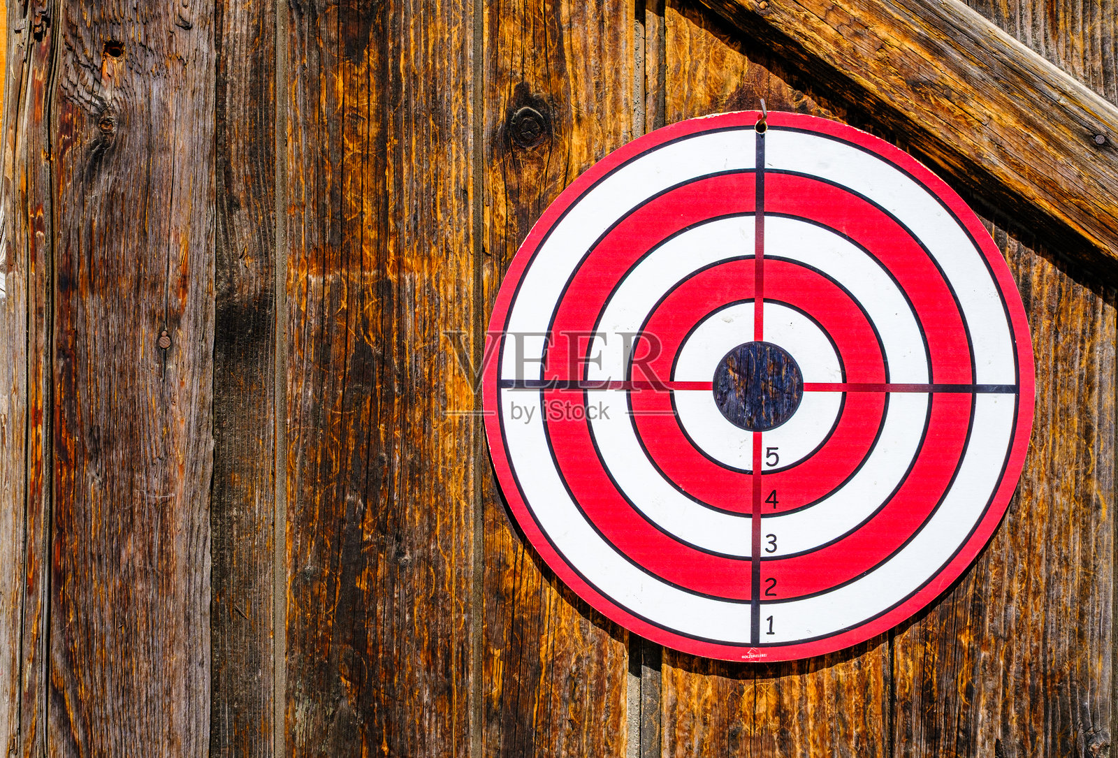 在乡村木质背景下的靶心靶场，正值正午户外光线。照片摄影图片