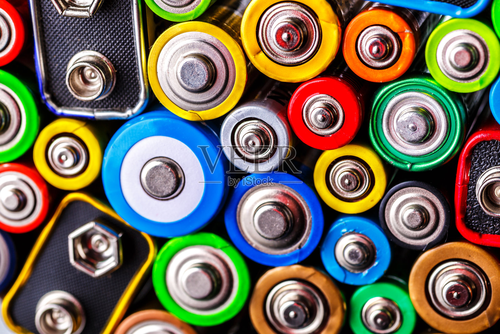 五颜六色的电池能量抽象背景。旧的废弃电池准备回收。来自不同制造商的废旧电池，废物、收集与回收，AA尺寸的碱性电池。照片摄影图片