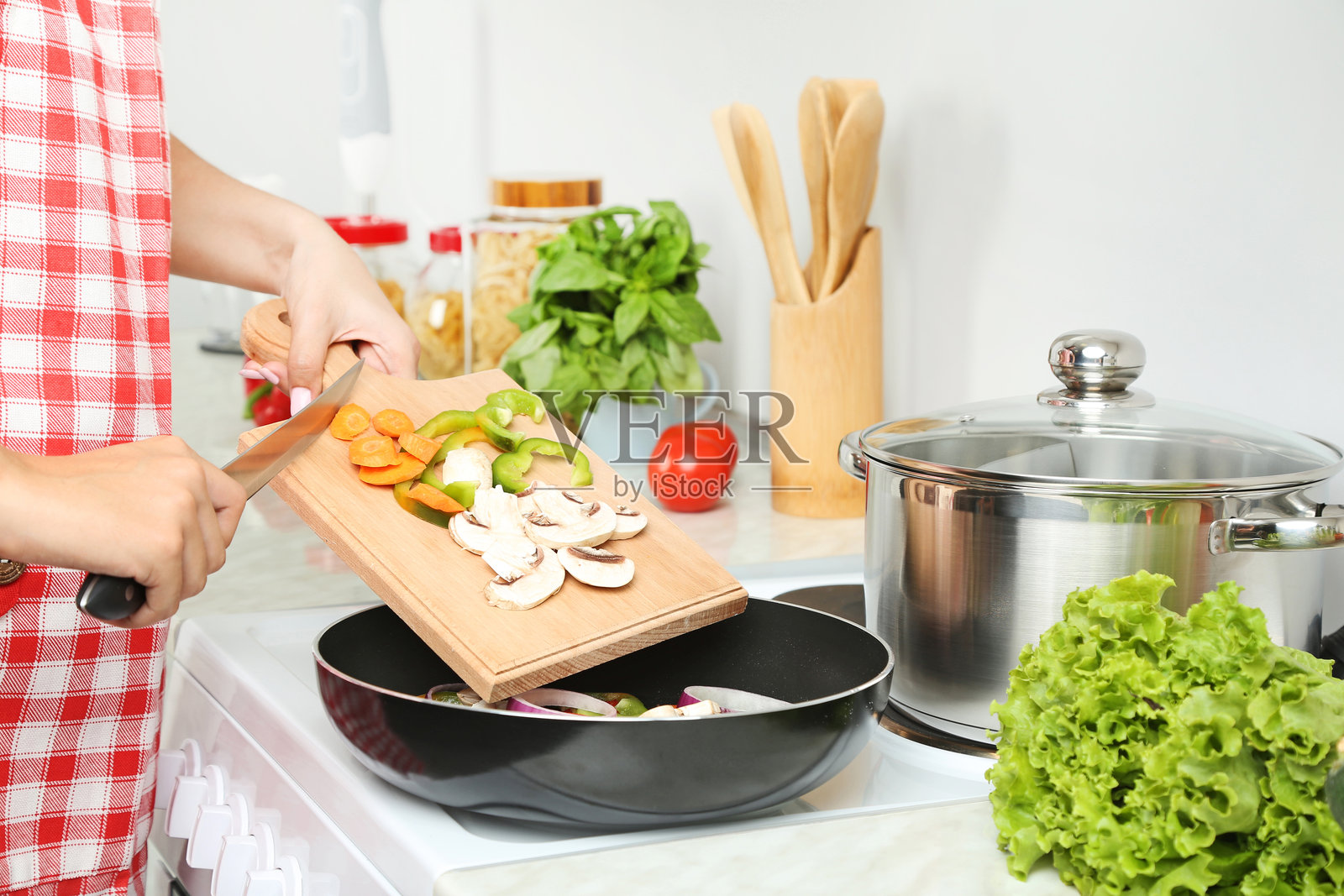年轻女性在厨房里做饭照片摄影图片