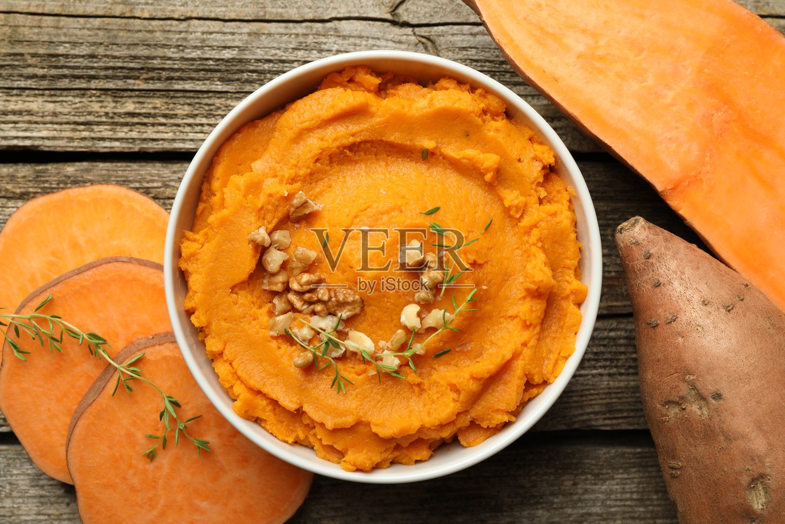 美味的土豆泥放在碗中，核桃和蔬菜摆放在木桌上，俯视图照片摄影图片