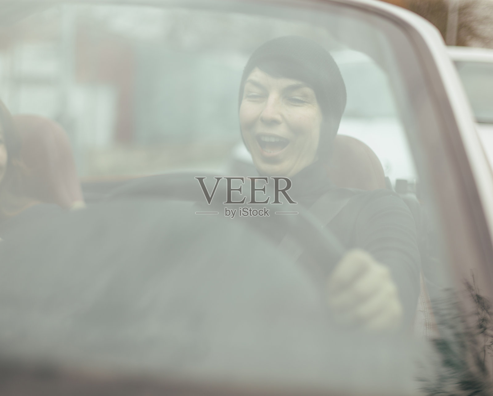 女性在充满活力的城市环境中驾驶汽车，周围是城市风景照片摄影图片