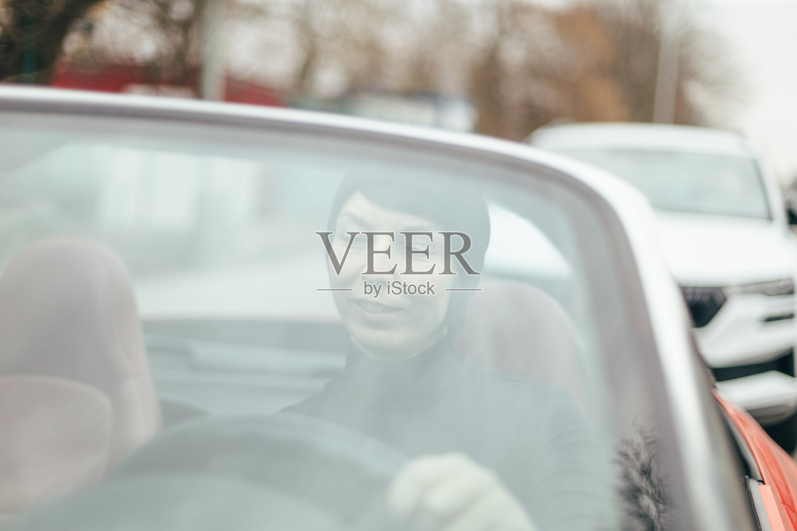 一位女性在繁忙的城市环境中驾驶一辆时尚的敞篷车照片摄影图片