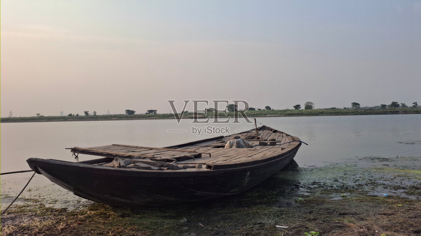 一只小船轻轻漂流在奔腾的河流上，融合了动与静，反映出大自然宁静的美丽和永恒的旅程。照片摄影图片