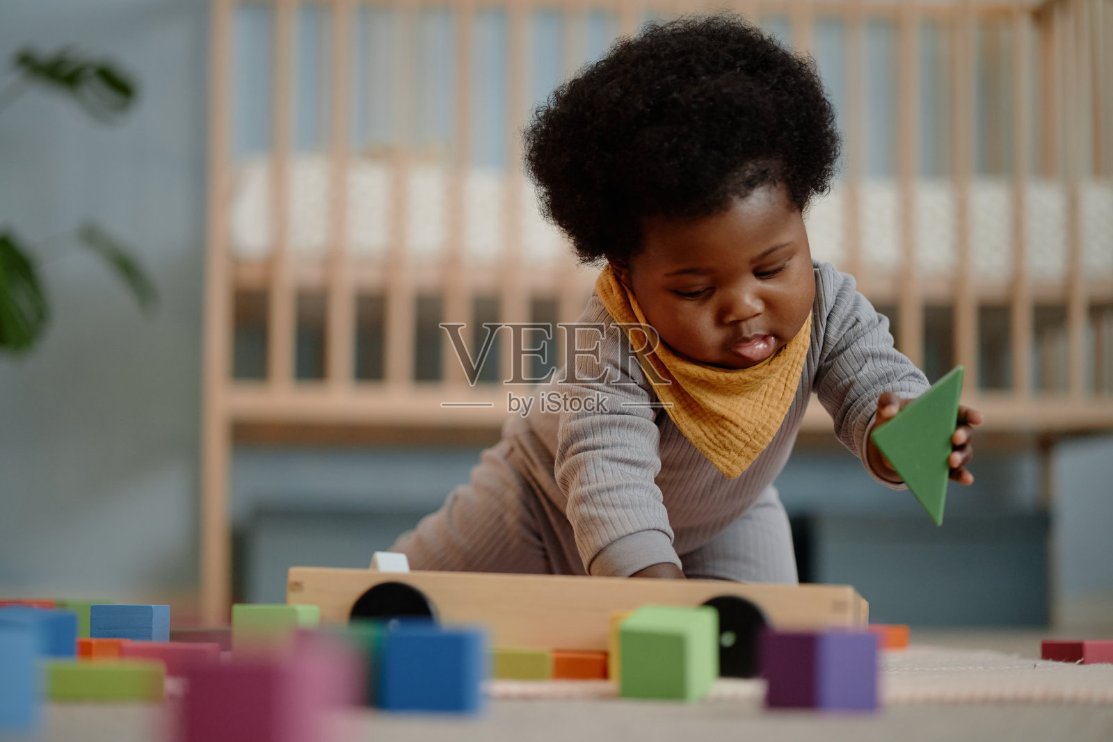 可爱的黑肤小孩在卧室地板上玩积木照片摄影图片