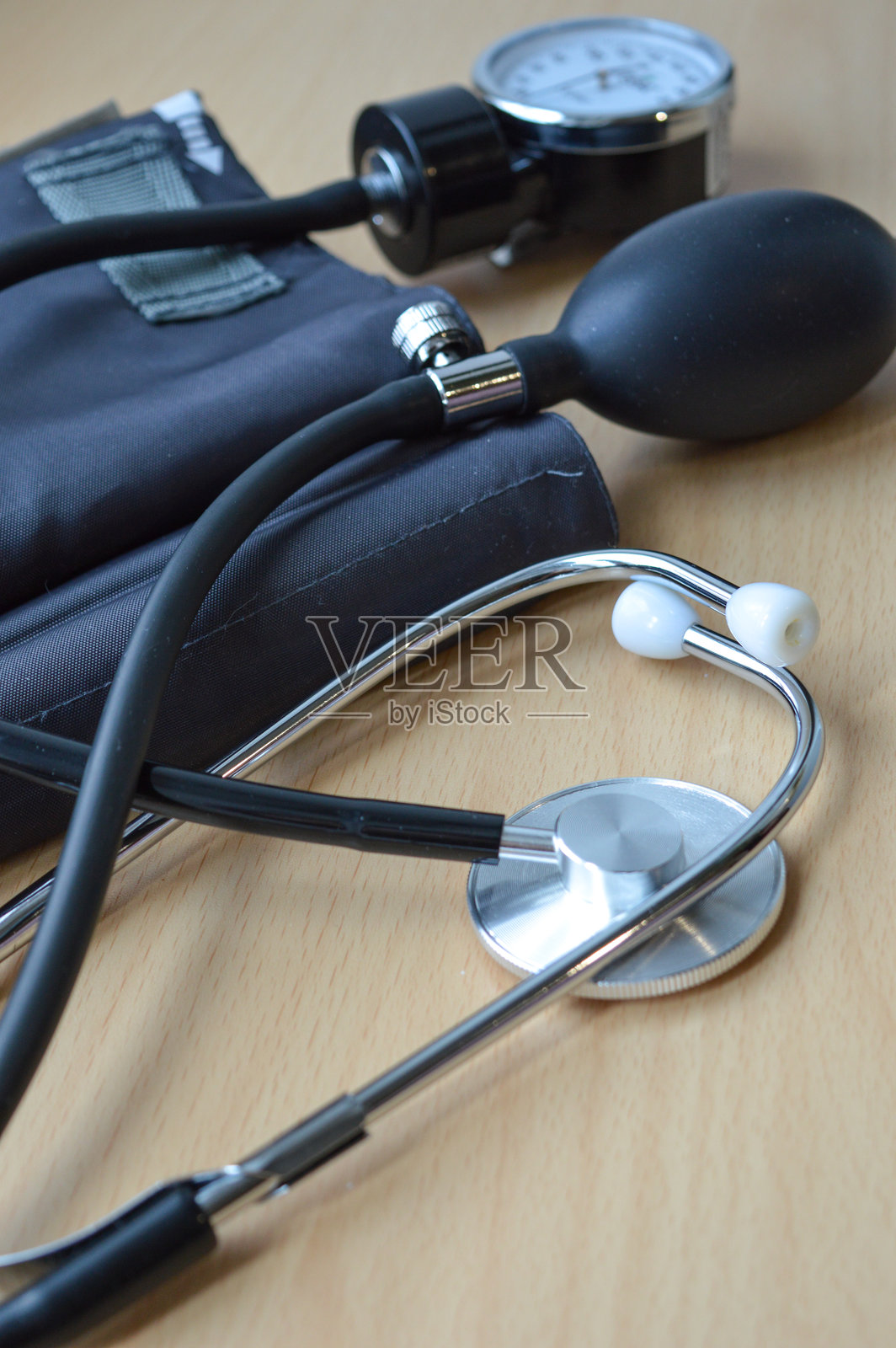 黑色听诊器和血压袖带放在木质表面上的医疗工具，诊断、医疗服务设备，健康保险视觉，医学学生培训的教育内容照片摄影图片