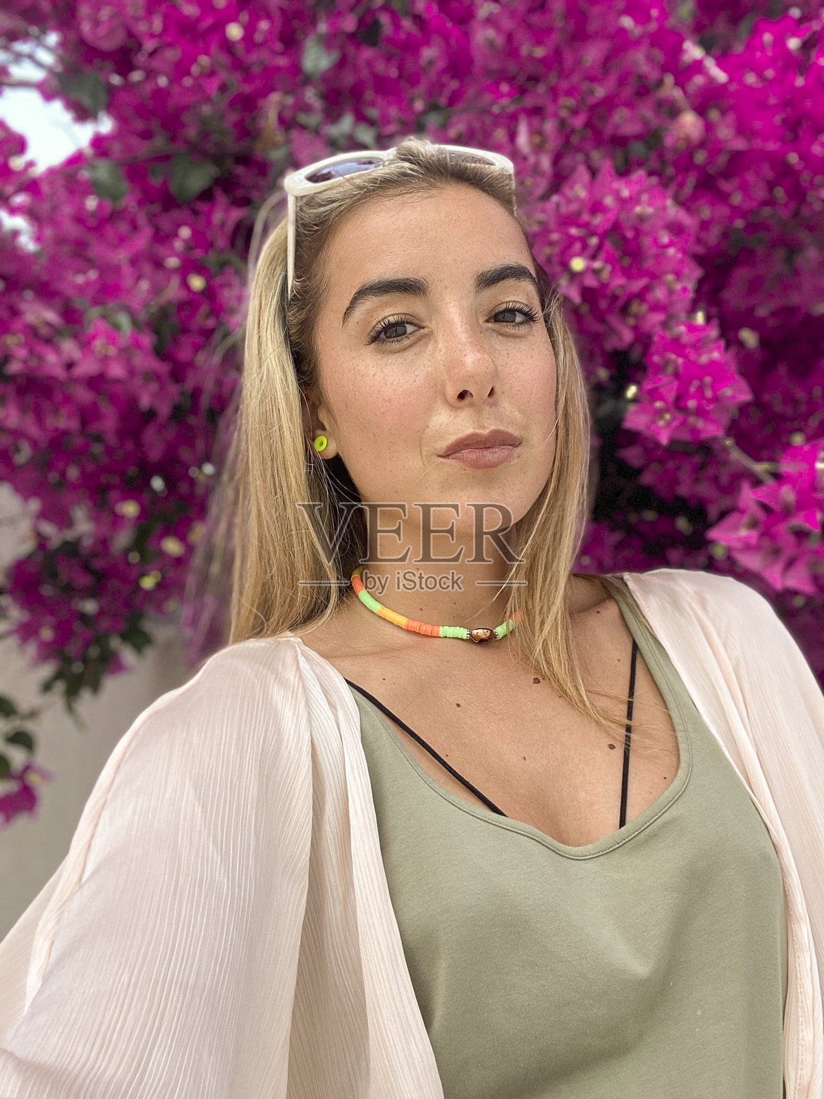 年轻女性在粉色花朵前自拍照片摄影图片