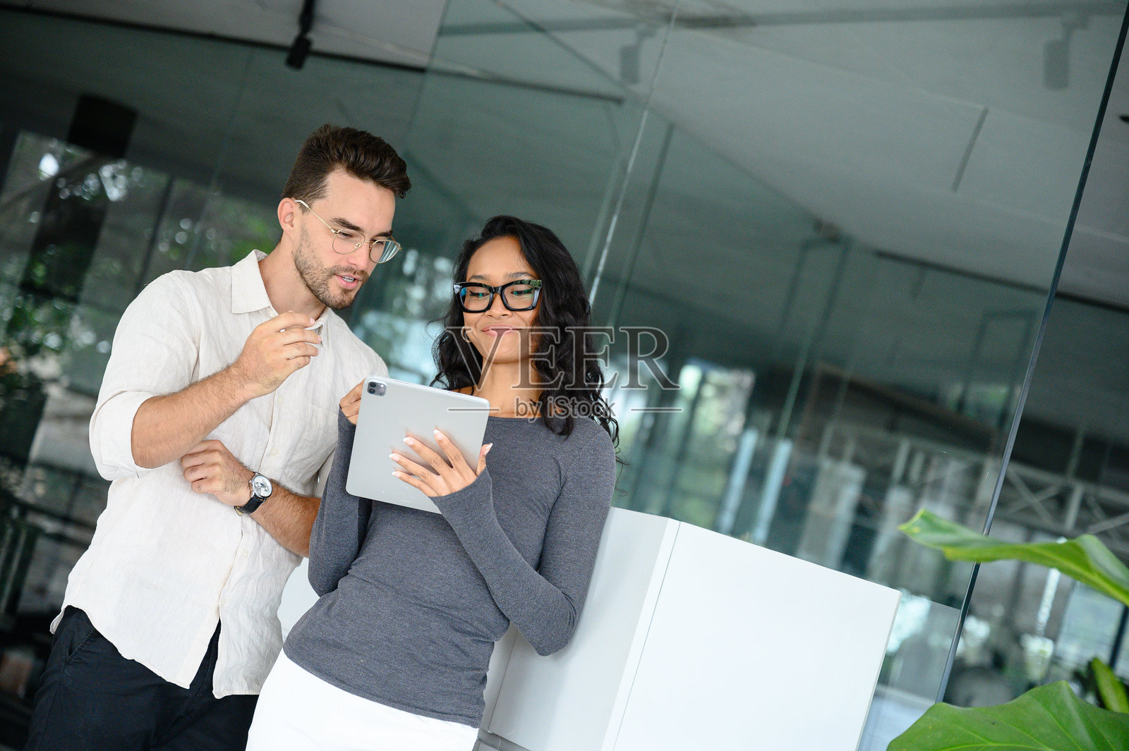 年轻专业人士在现代办公室空间中审阅数字内容照片摄影图片