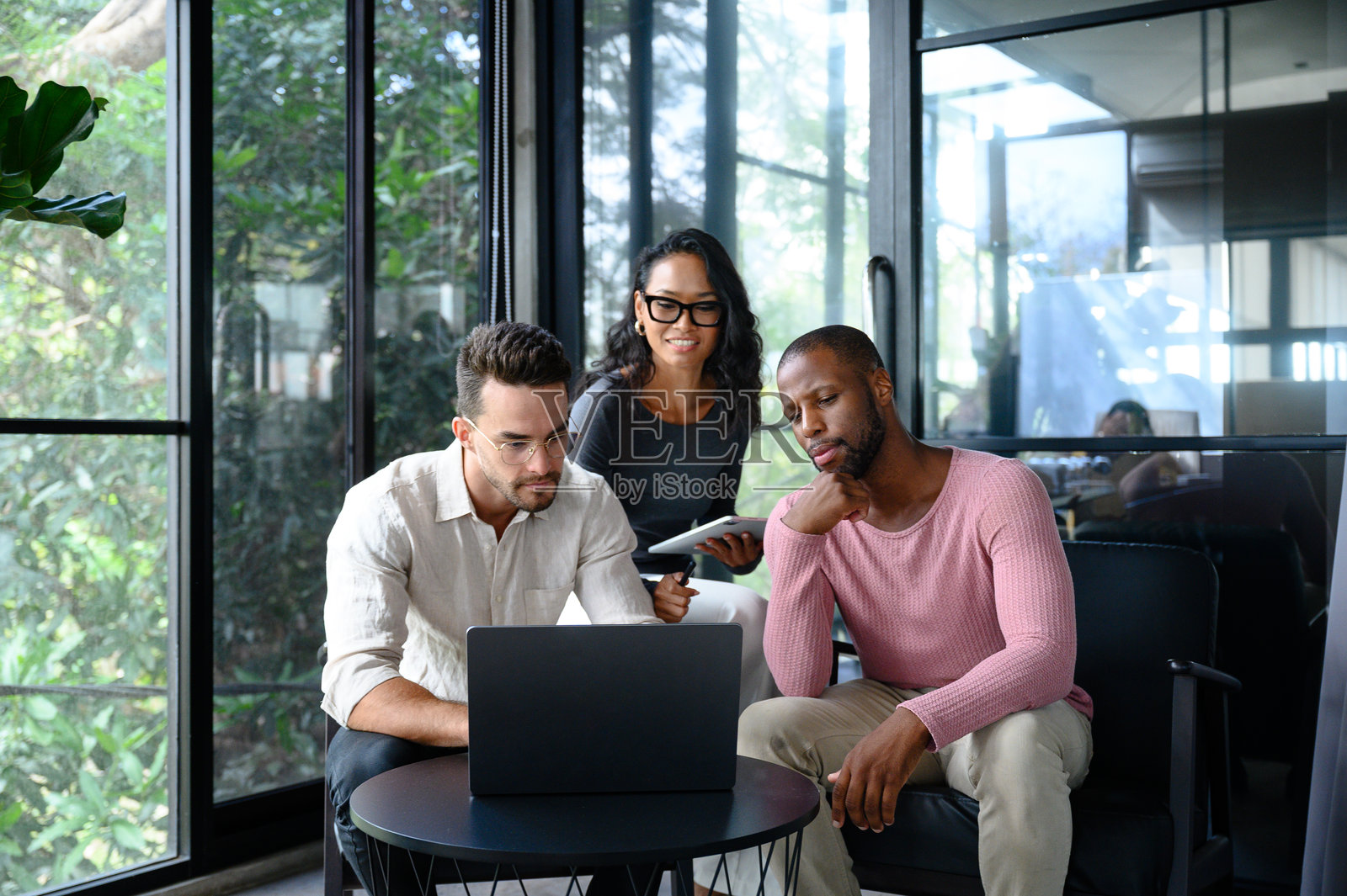 多元化的商业团队在现代办公室内合作，享受自然光照照片摄影图片