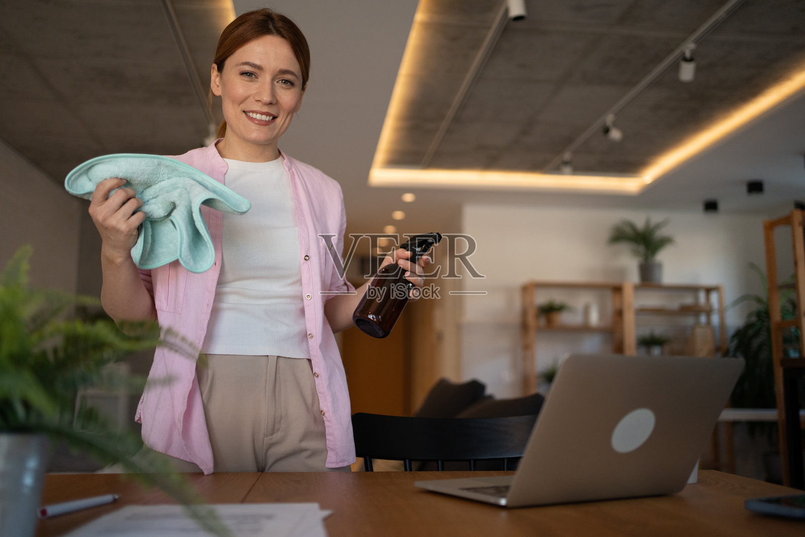 微笑的管家手持清洁用品并看向镜头照片摄影图片