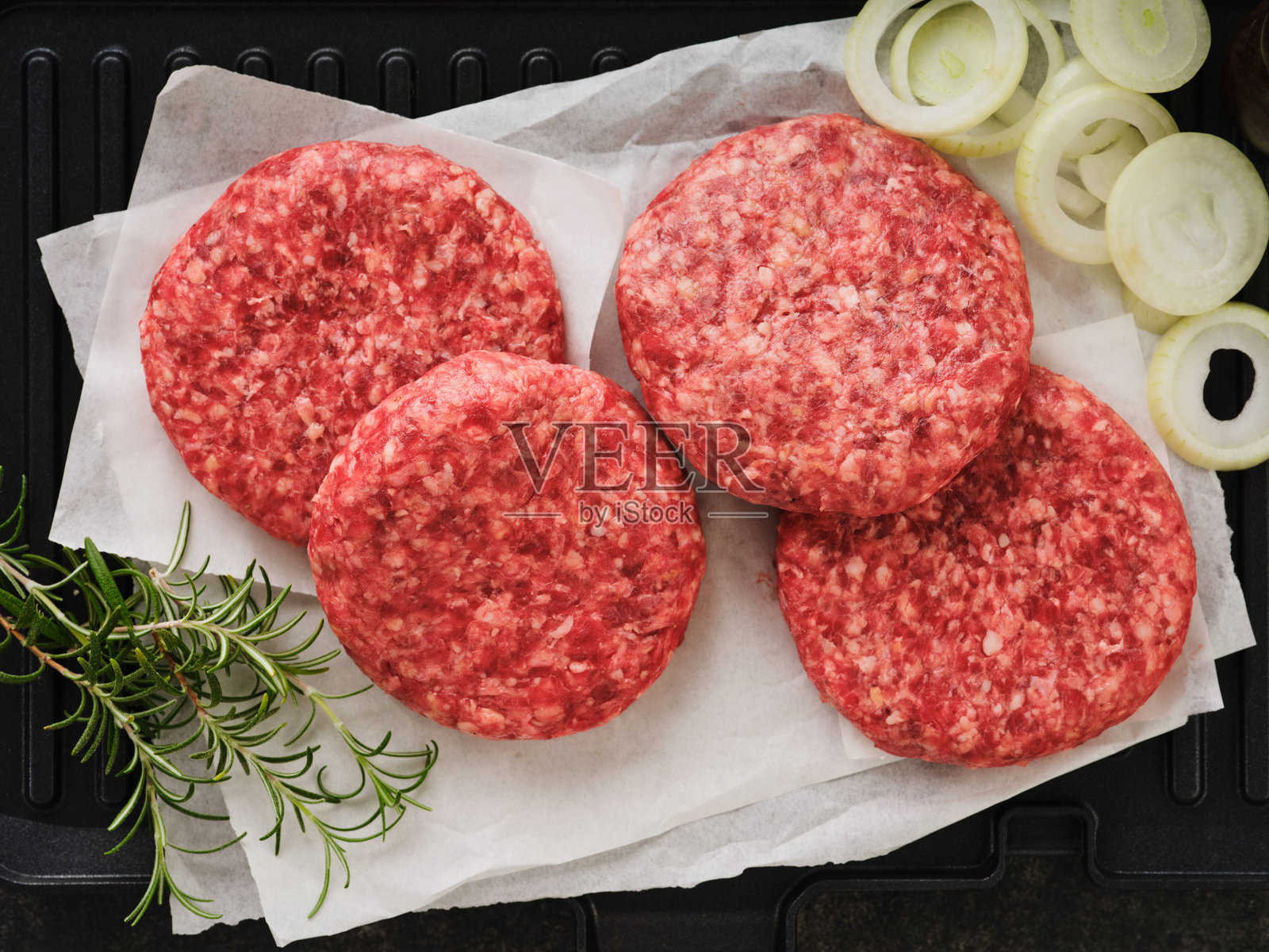 四个新鲜生牛肉汉堡饼或牛肉切块在深色木质背景上。俯视图。照片摄影图片