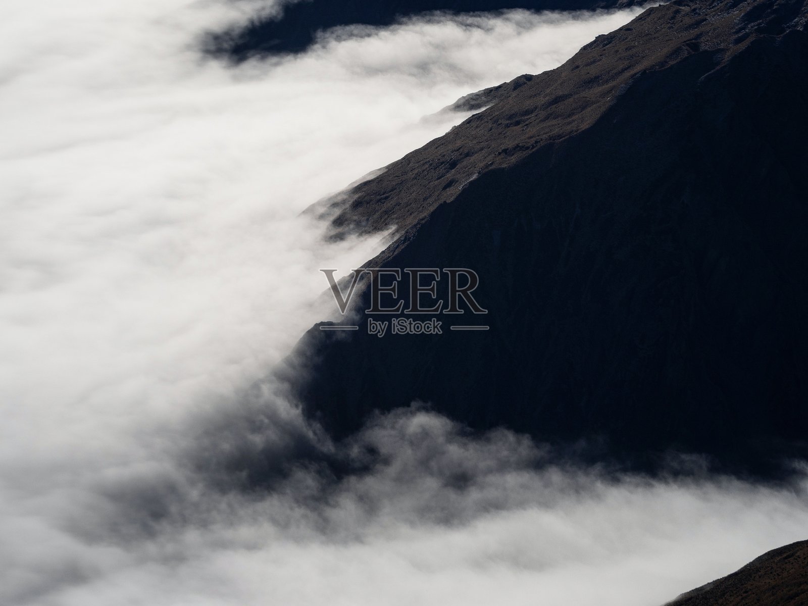 南阿尔卑斯山的空中全景，雪山巅峰高耸于云层之上，位于新西兰南岛的奥塔哥南部。照片摄影图片