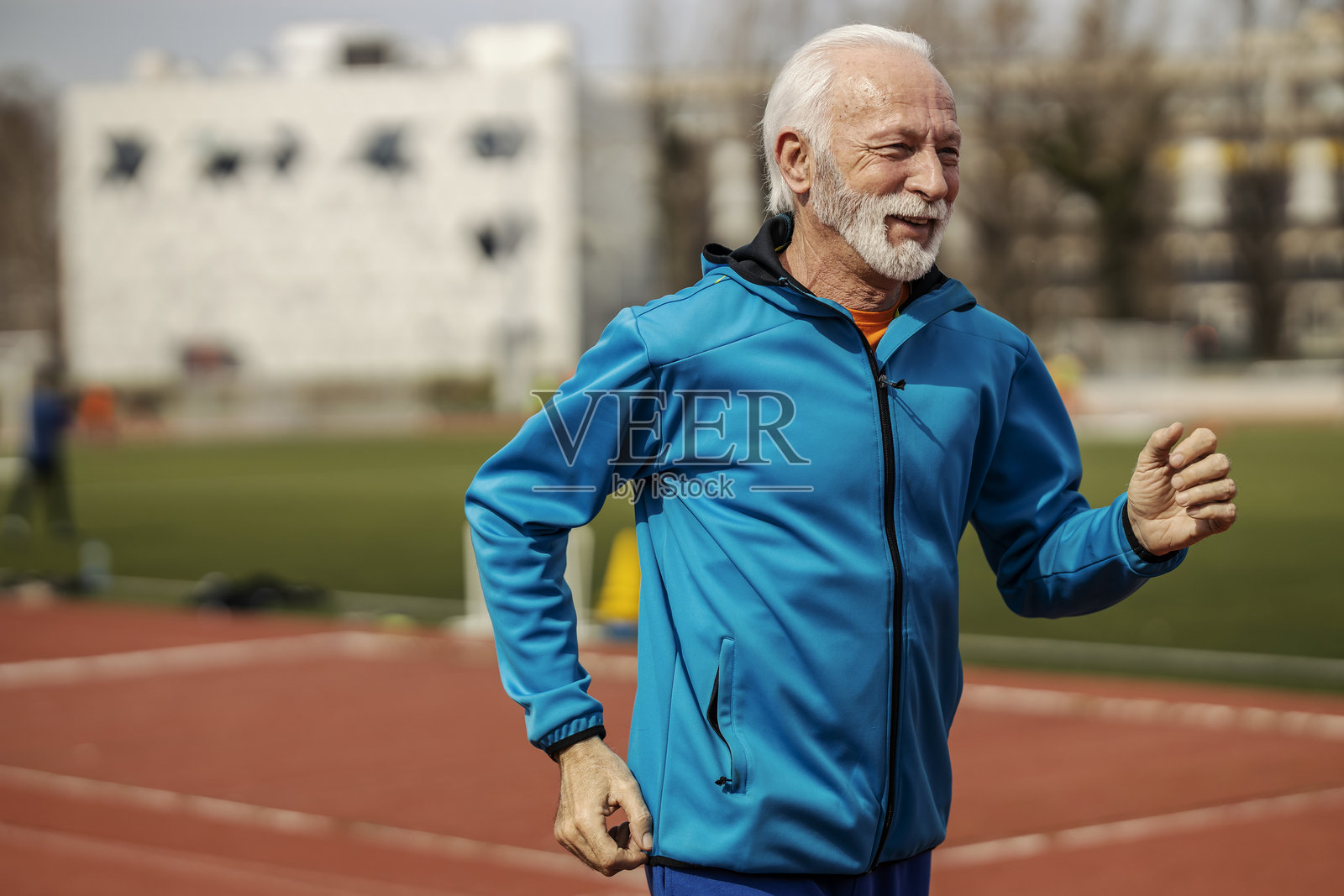 老年跑者在体育场跑步。照片摄影图片