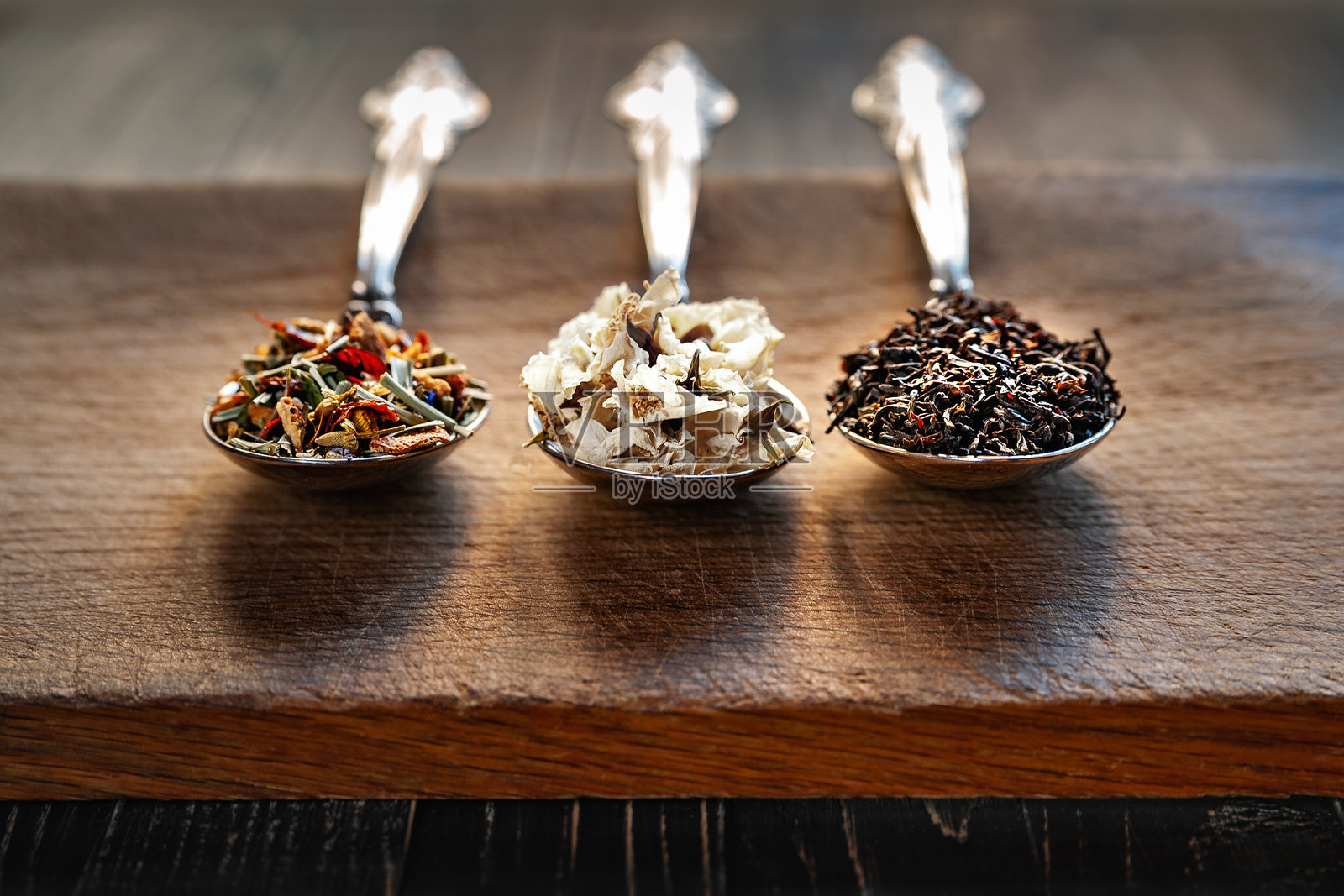 干茶的组合。各种茶叶在勺子中。各种茶叶和茉莉花。由不同草药制成的各种茶的组合。茶的概念。照片摄影图片