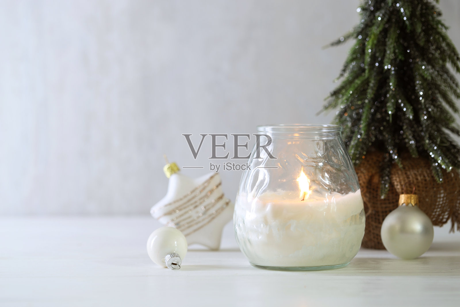 白色木桌上的燃烧蜡烛和圣诞装饰，特写。留有文字空间。照片摄影图片