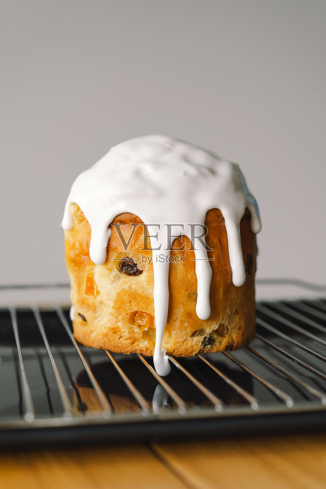 在春季准备期间，在厨房台面上烘焙节日复活节潘纳托尼蛋糕，并在上面涂抹糖霜。照片摄影图片