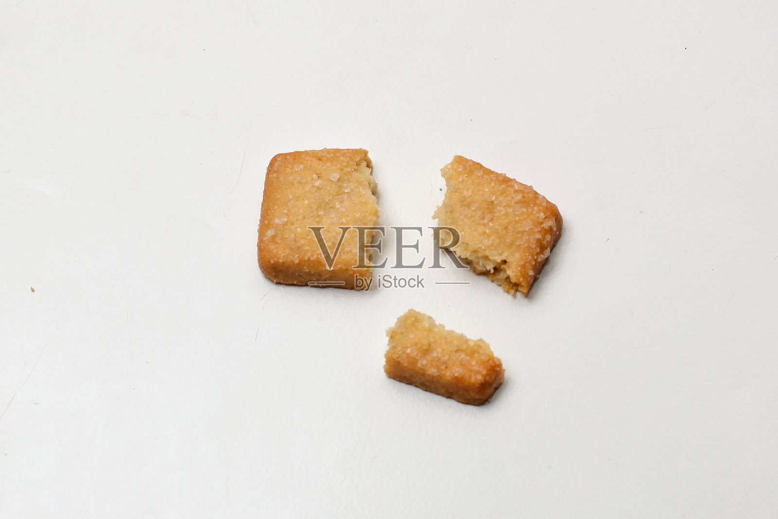 破碎的丹麦饼干在白色背景上，分成三块照片摄影图片