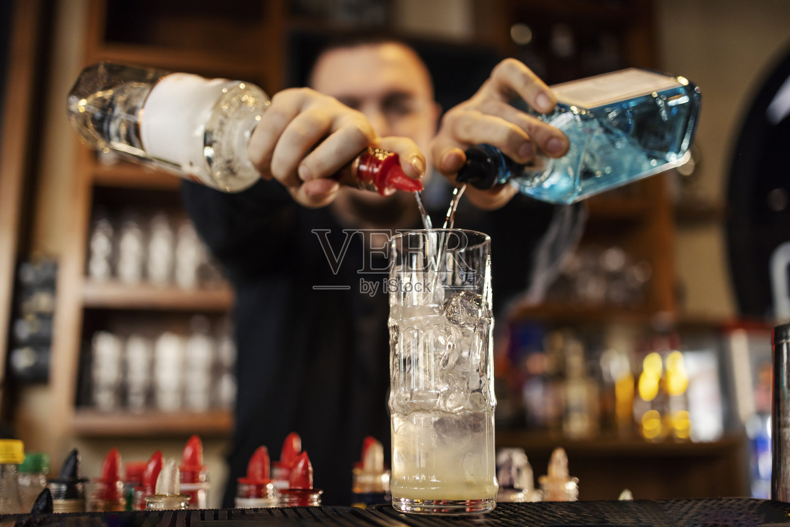 调酒师在酒吧调制鸡尾酒的特写镜头。照片摄影图片