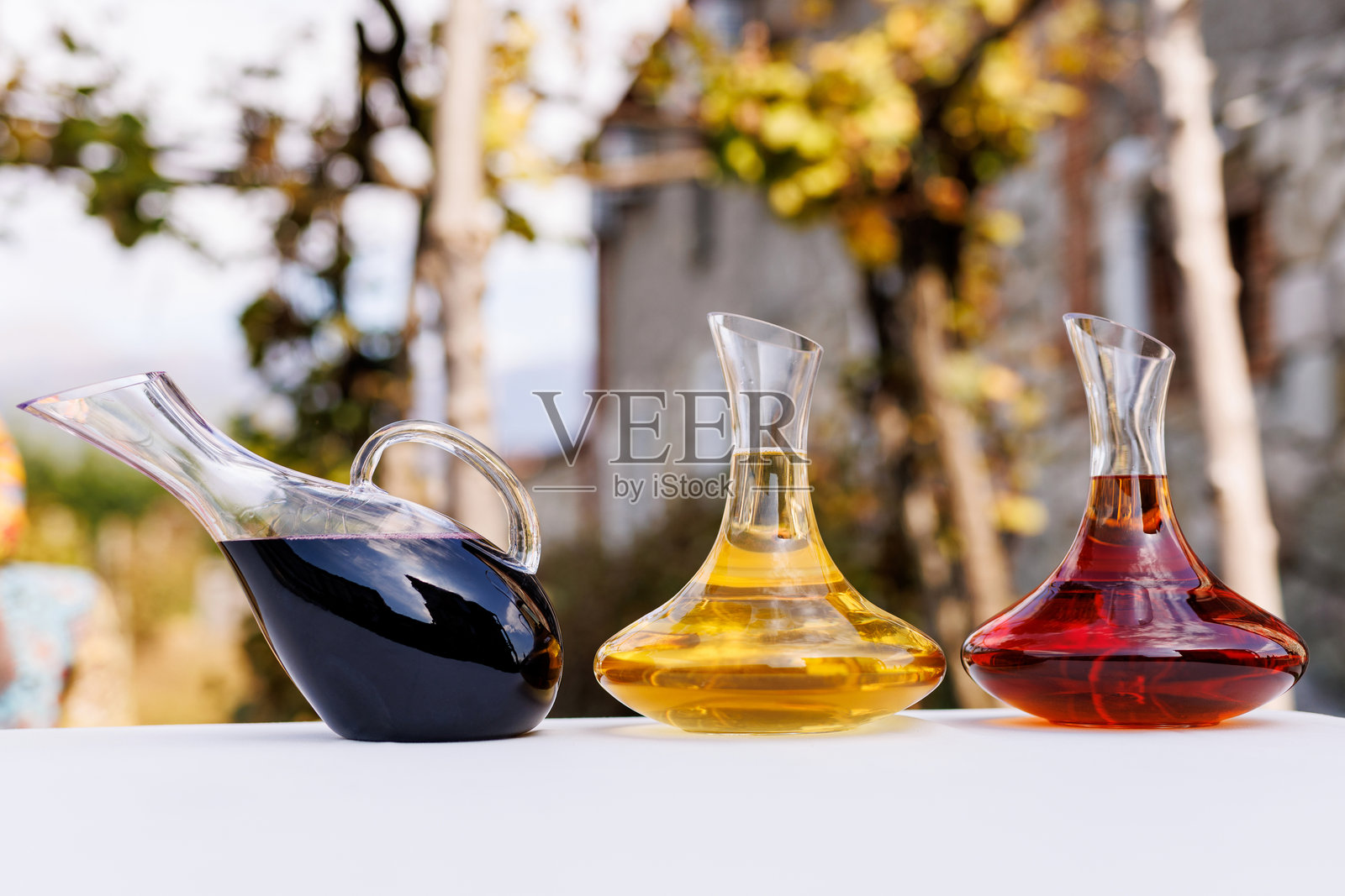 桌子上有三个酒杯，其中一个是红色的。照片摄影图片