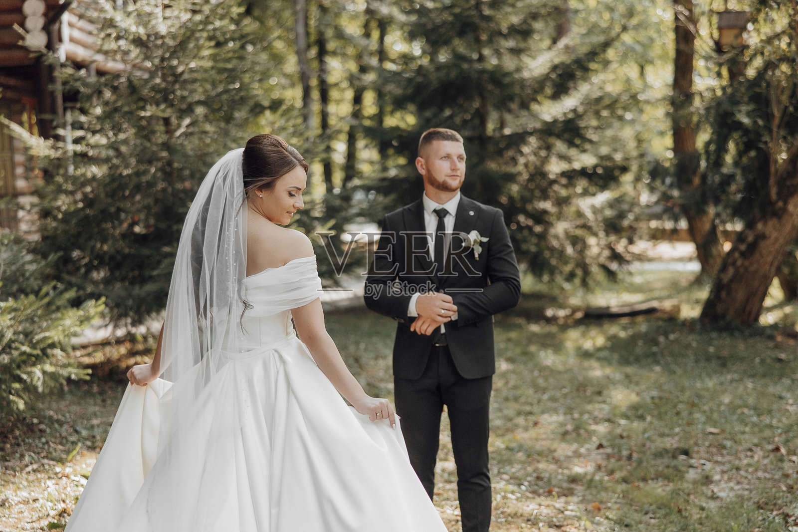 一对新郎新娘站在森林空地上照片摄影图片