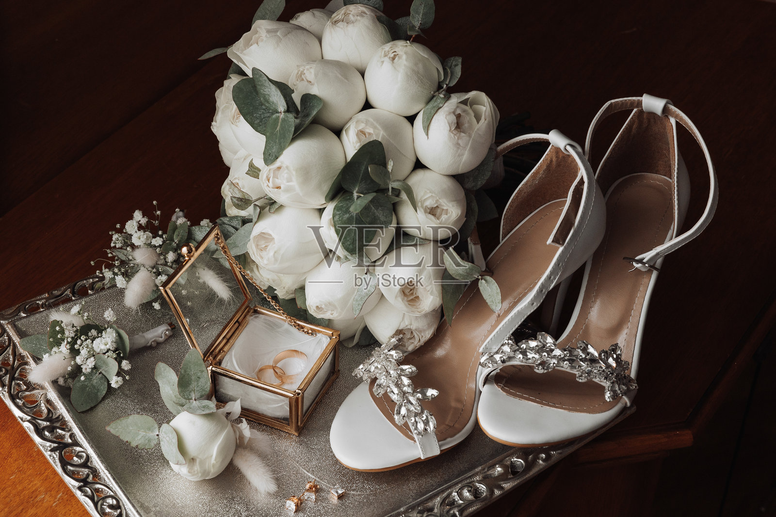 一个托盘上放着一束白色花朵和一双白色鞋子照片摄影图片
