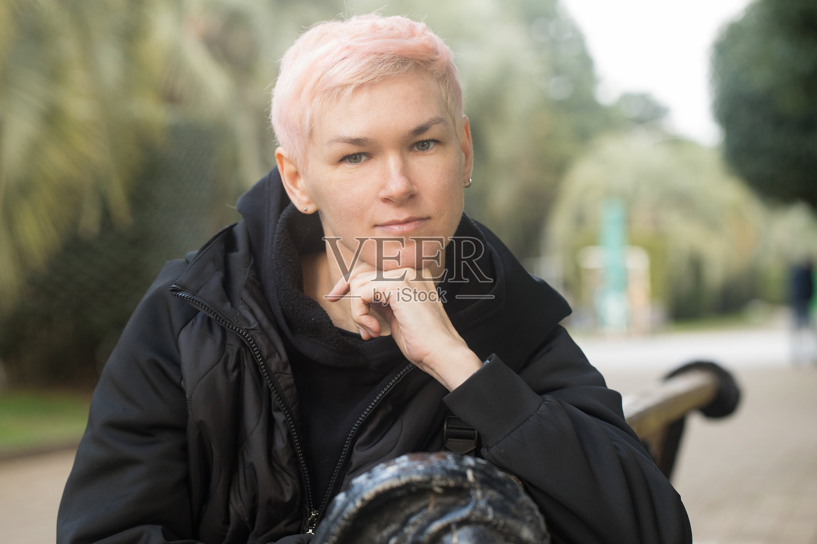 优雅的成熟的女性坐在公园长椅上照片摄影图片