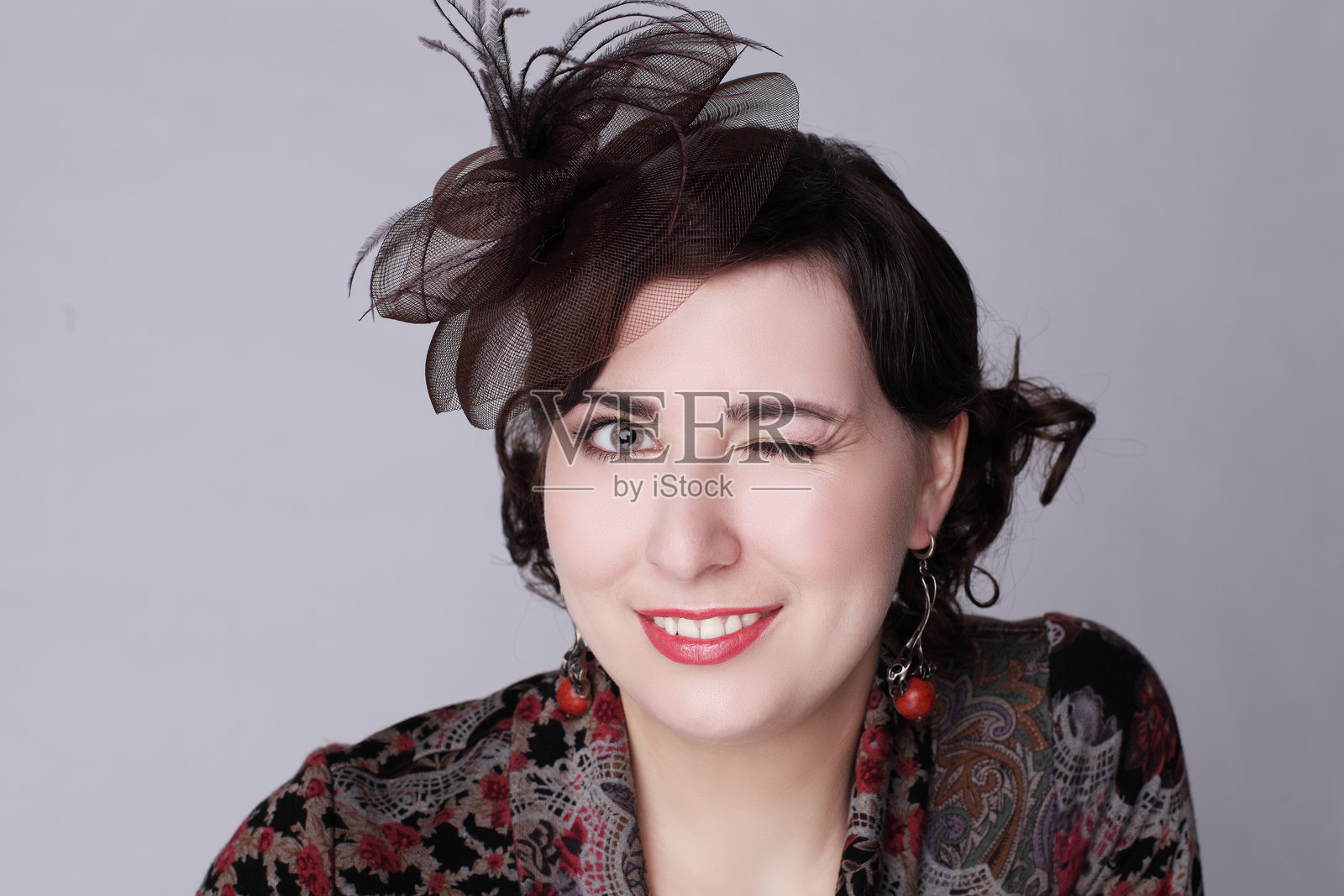 眨眼的棕发女性，戴着红色帽子，复古风格时尚美容肖像照片摄影图片