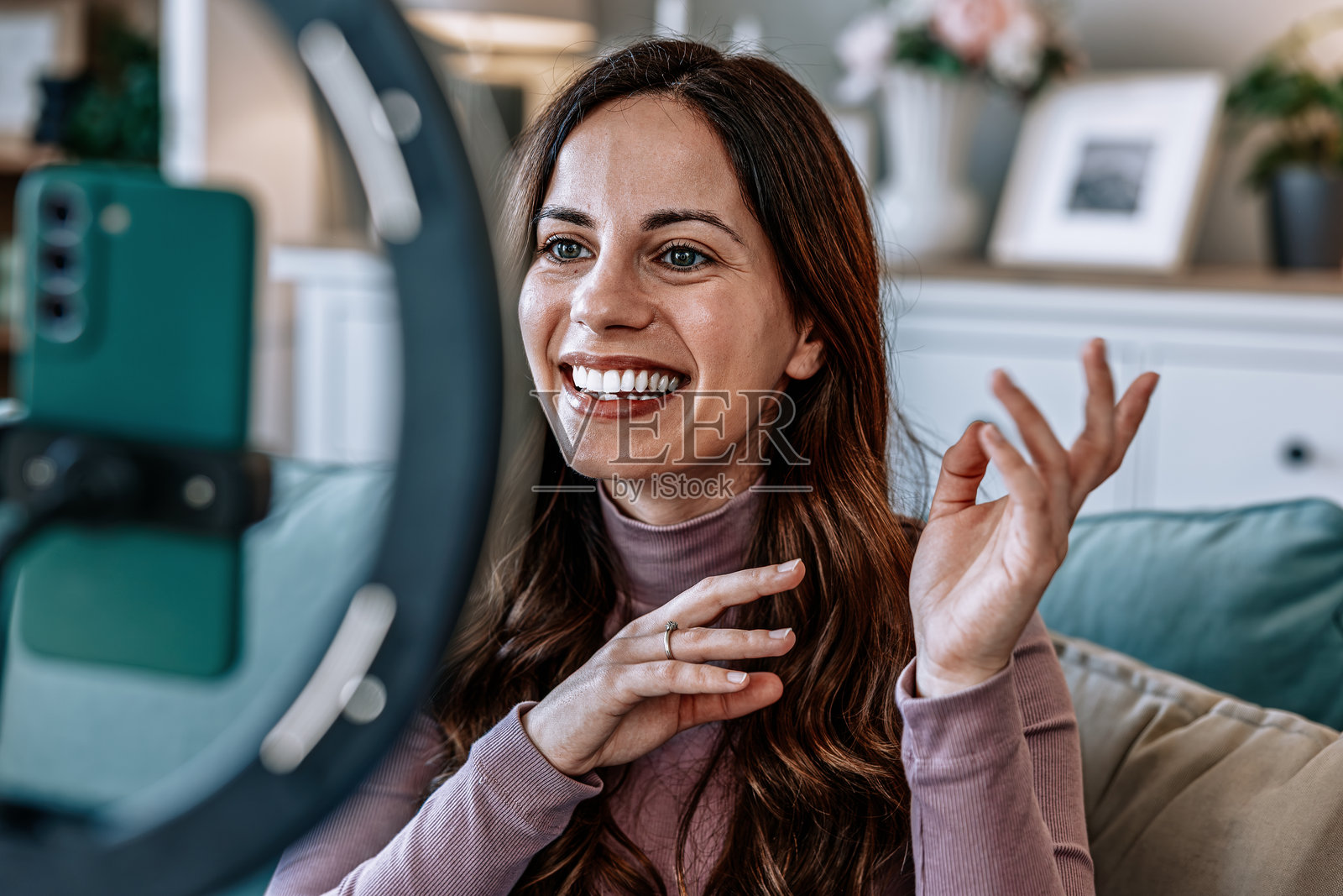 快乐的女性网红在家用智能手机和环形灯录制视频内容照片摄影图片