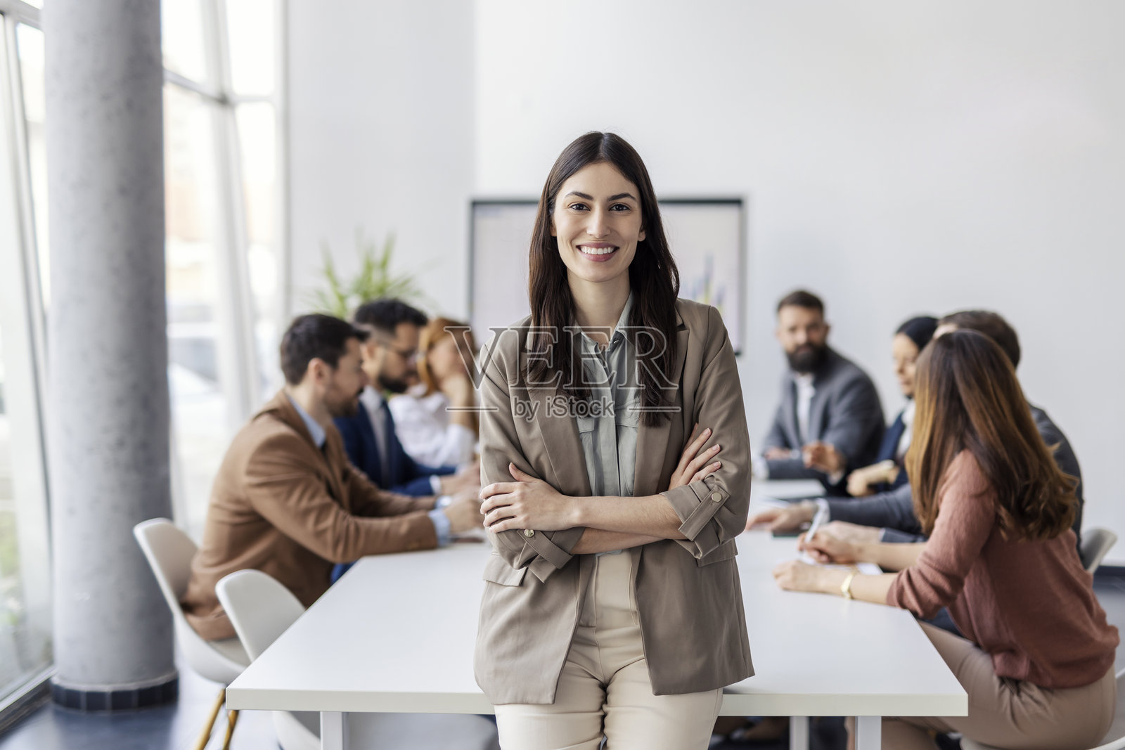 年轻的女性专业人士在公司会议室里微笑着看向镜头。照片摄影图片