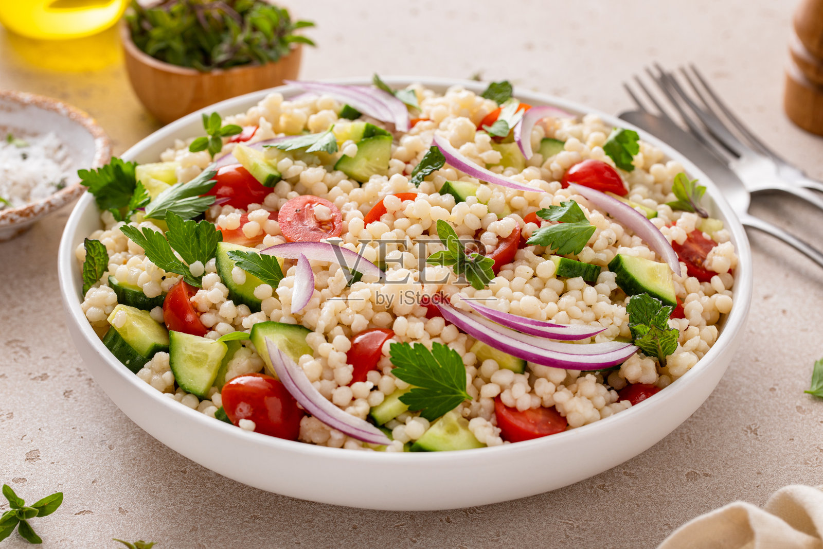 珍珠蒸粗麦粉沙拉配新鲜蔬菜和红洋葱照片摄影图片