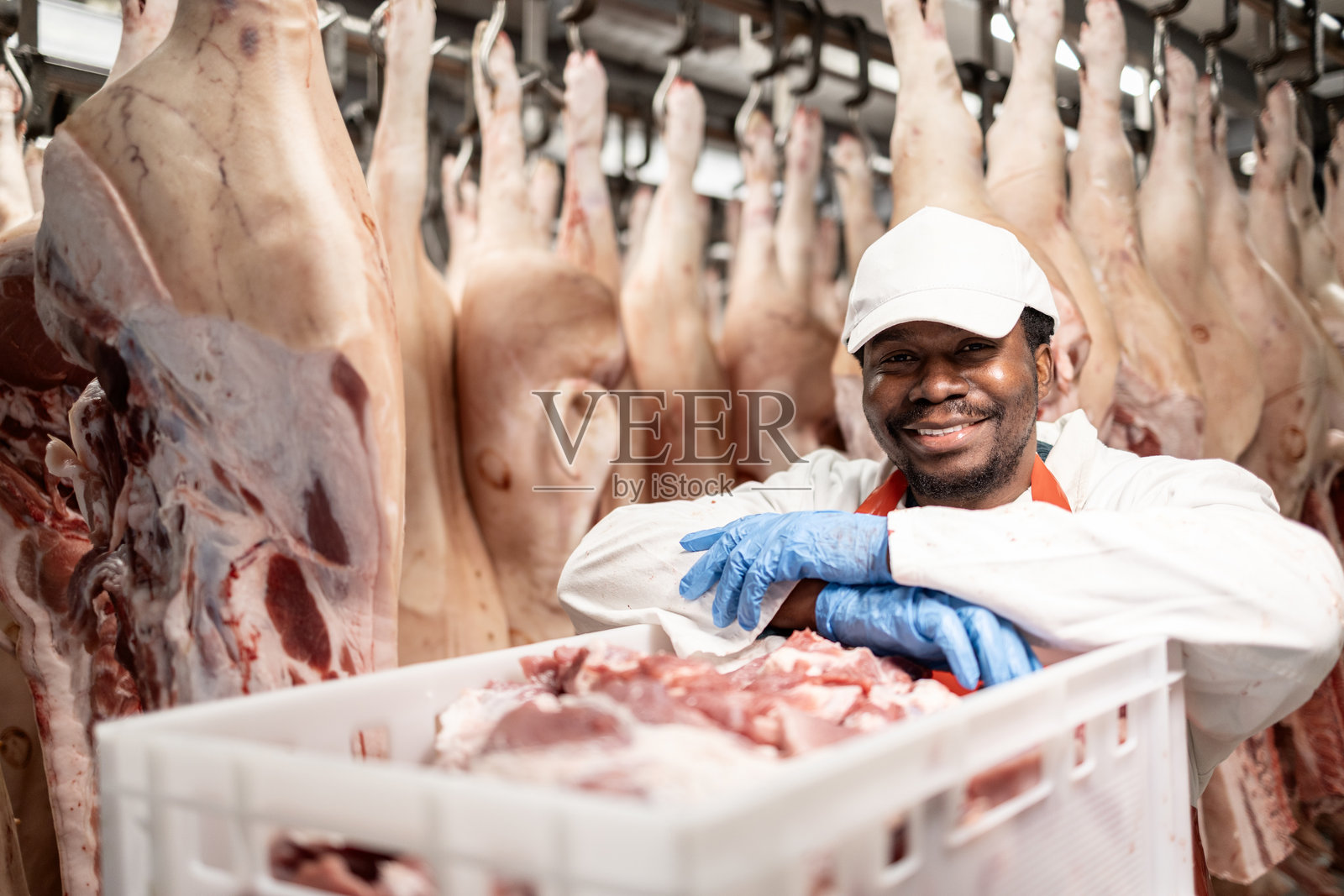 食品工厂工人在屠宰场搬运切好的生肉。照片摄影图片