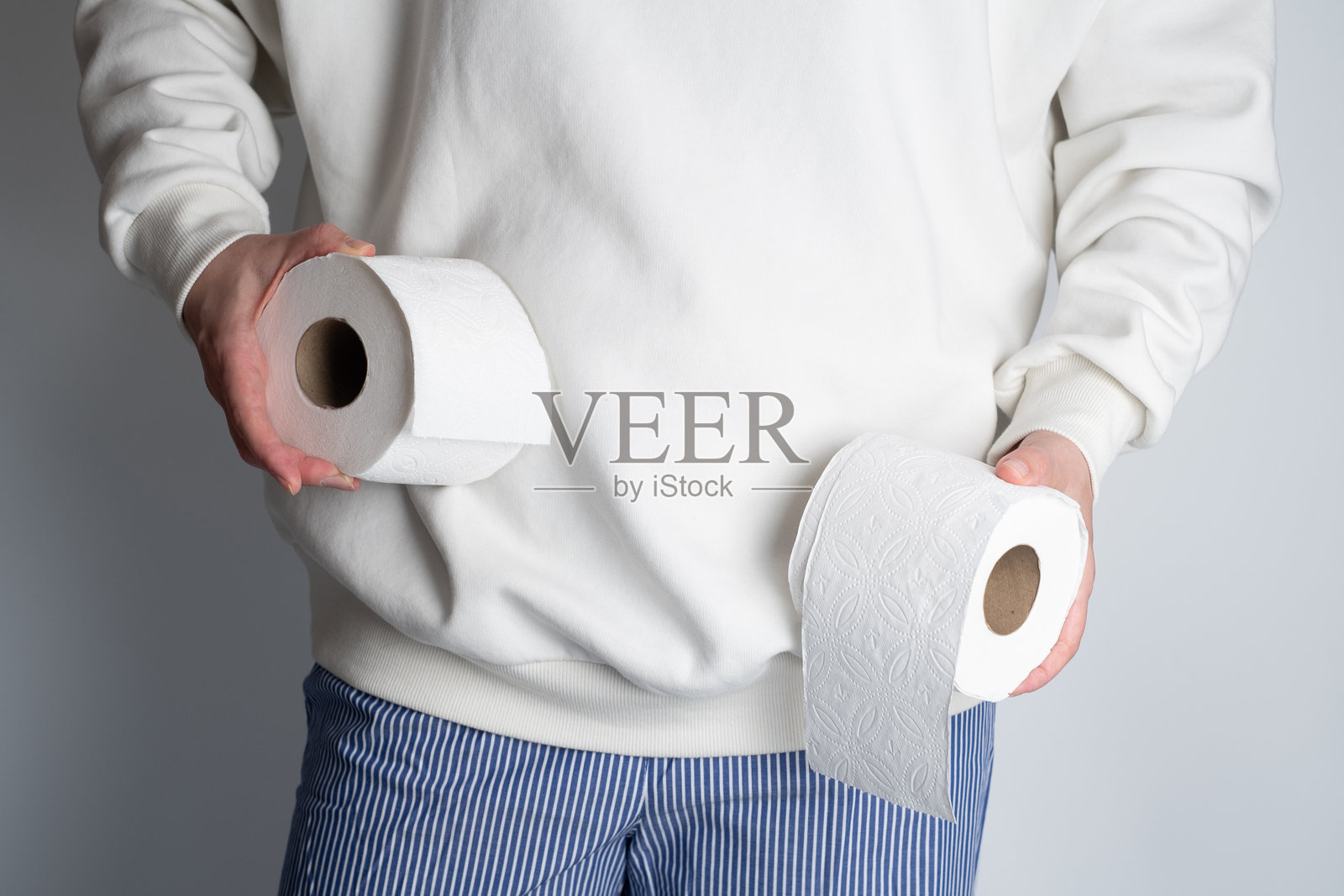 女人的手握着柔软的白色卫生纸卷。卫生概念。特写镜头。照片摄影图片