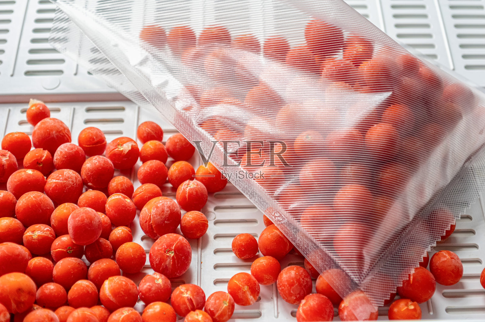 真空密封袋中的冷冻樱桃番茄照片摄影图片